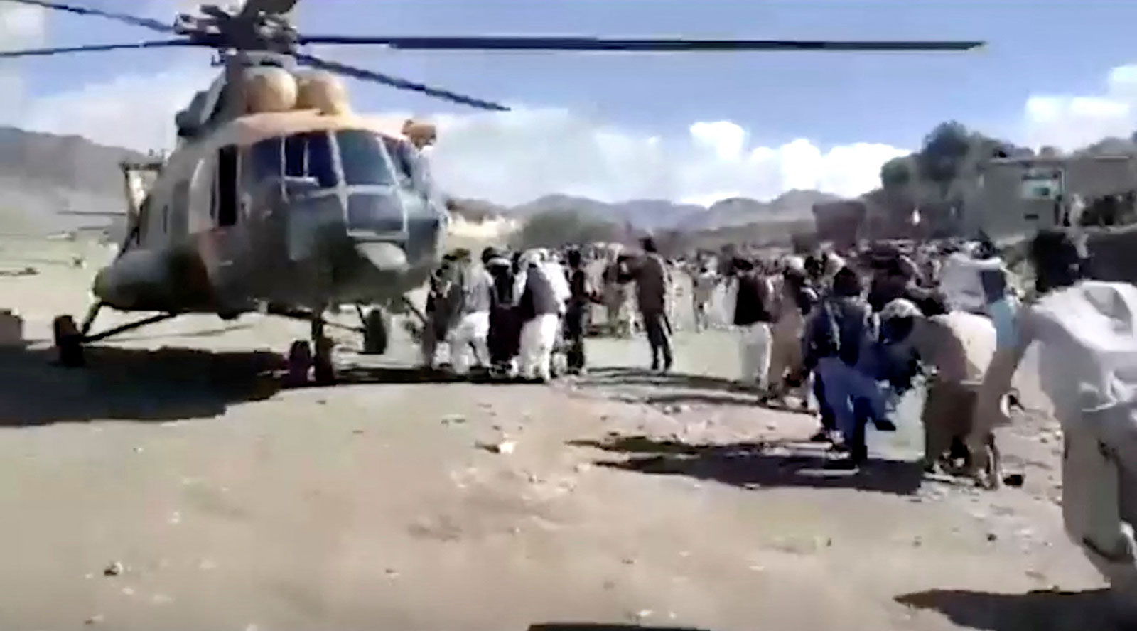 People carry the injured to a helicopter following a massive earthquake in Paktika province, Afghanistan, on June 22 in this screen grab taken from a video.