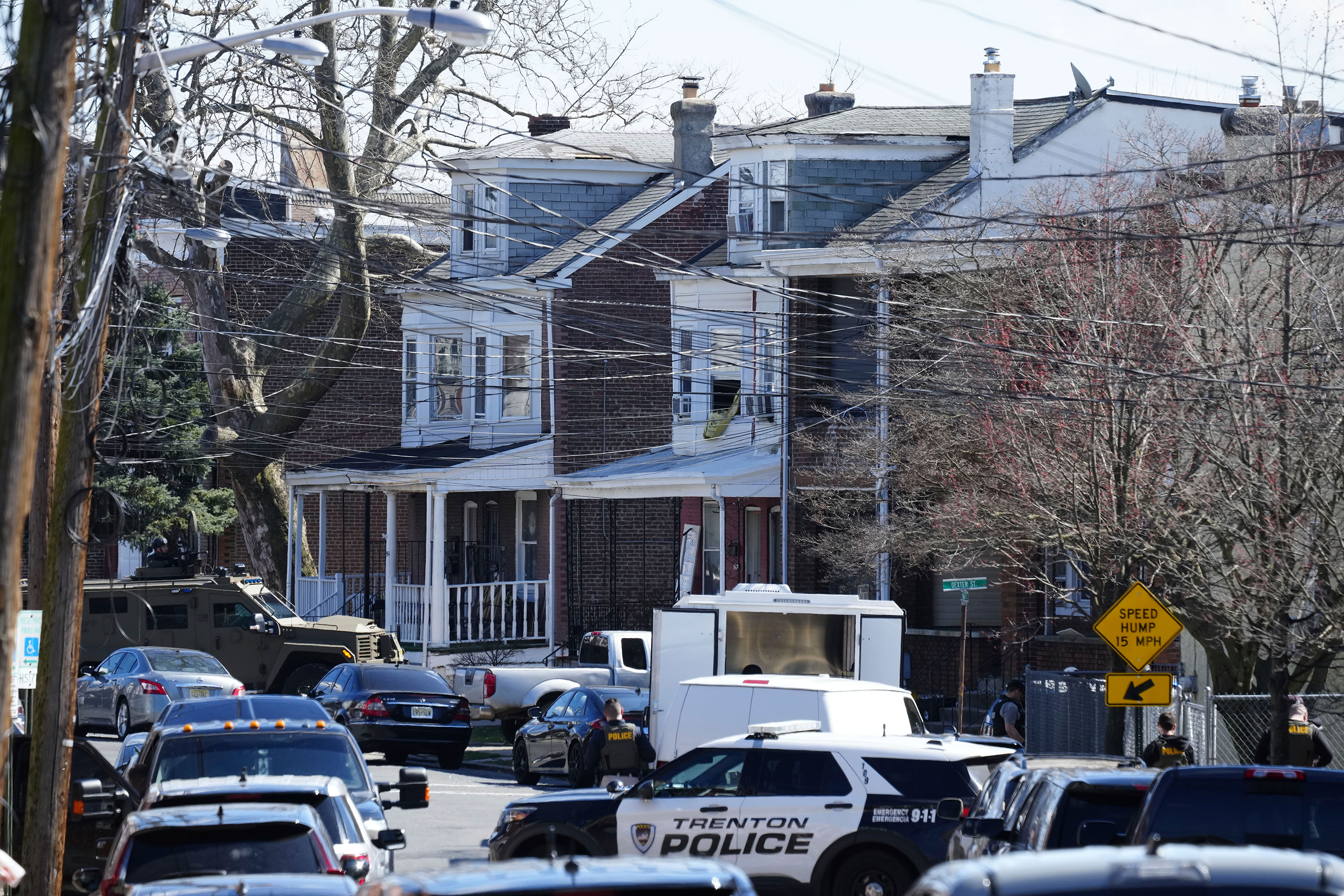 Police surround a home in Trenton, New Jersey, where the man suspected of killing three people is believed to be on Saturday. 