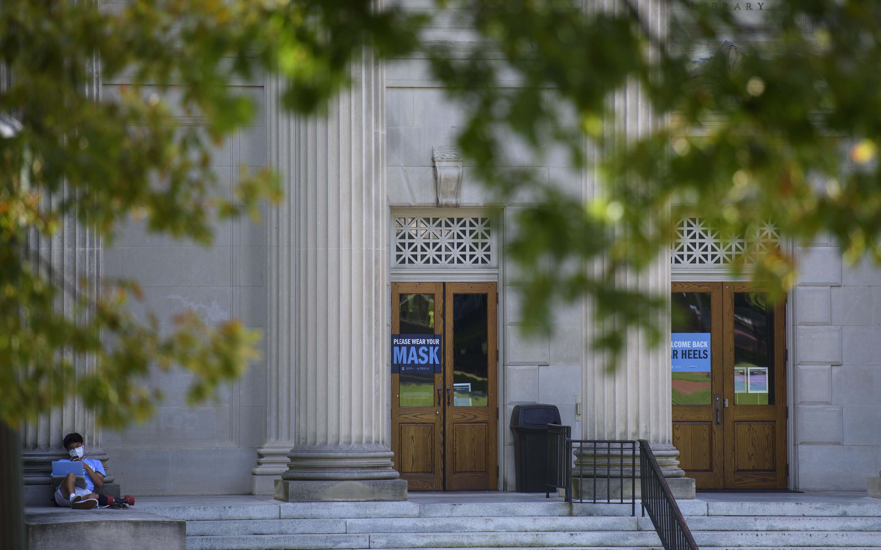 A student studies outside the closed Wilson Library on the campus of the University of North Carolina at Chapel Hill on August 18, in Chapel Hill, North Carolina.