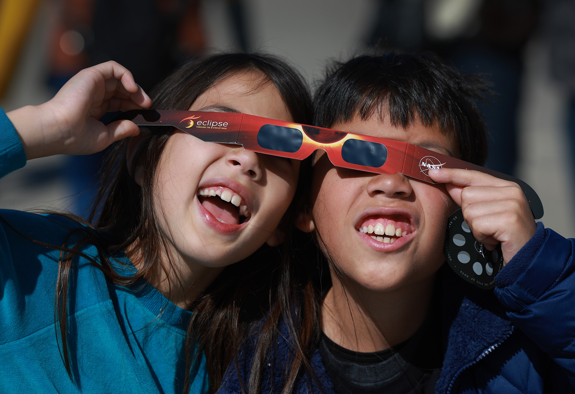 Miriam and Oliver Toy share a pair of eclipse glasses as they await the eclipse in Houlton, Maine. 