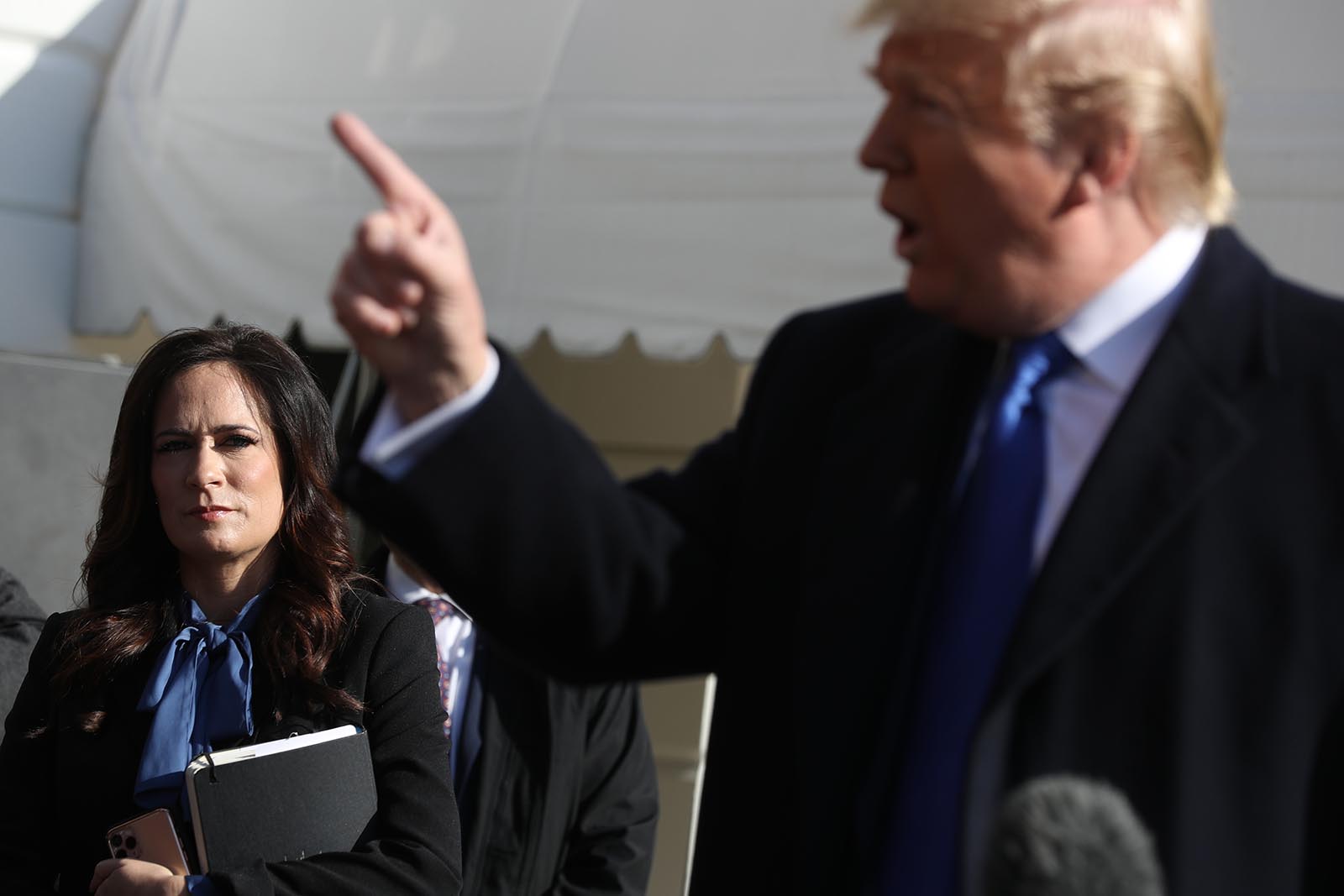 White House Press Secretary Stephanie Grisham listens to U.S. President Donald Trump talk to reporters before he boards Marine One and departing the White House November 08, 2019 in Washington.