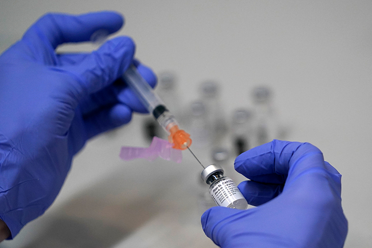 A pharmacy technician loads a syringe with Pfizer's COVID-19 vaccine, Tuesday, March 2, 2021 at a mass vaccination site at the Portland Expo in Portland, Maine. 