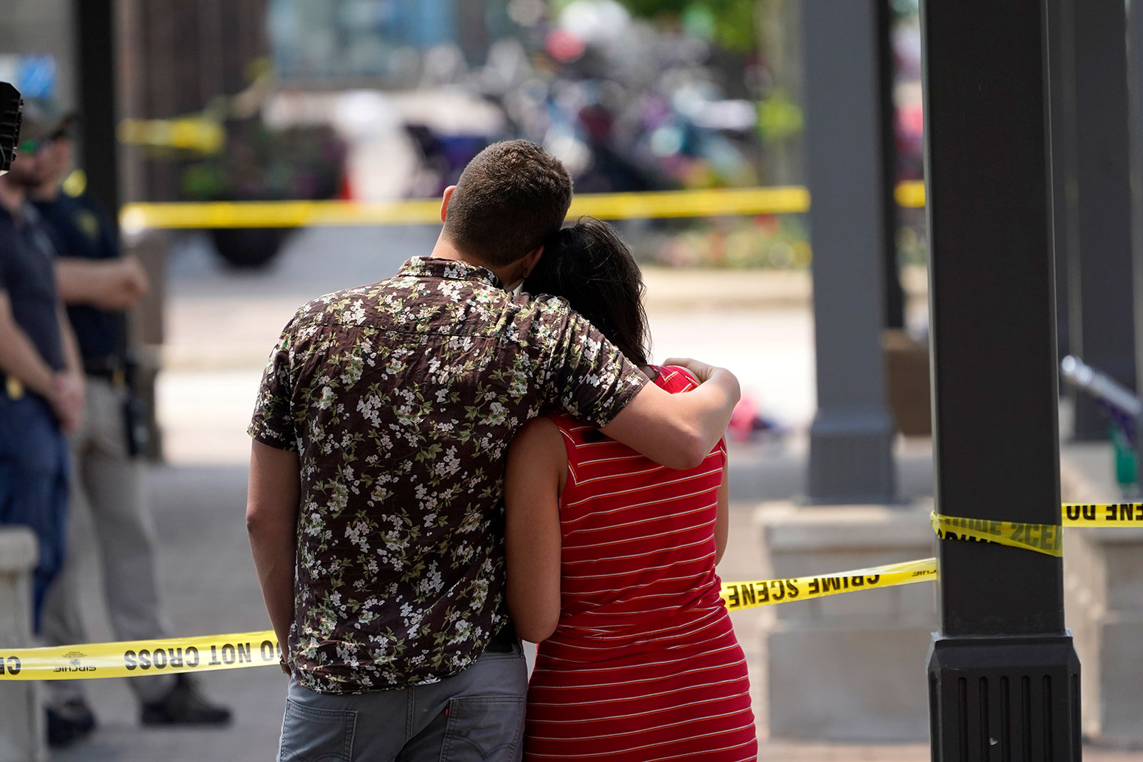 A couple looks toward the scene of the mass shooting in downtown Highland Park, Illinois, on Tuesday, July 5.