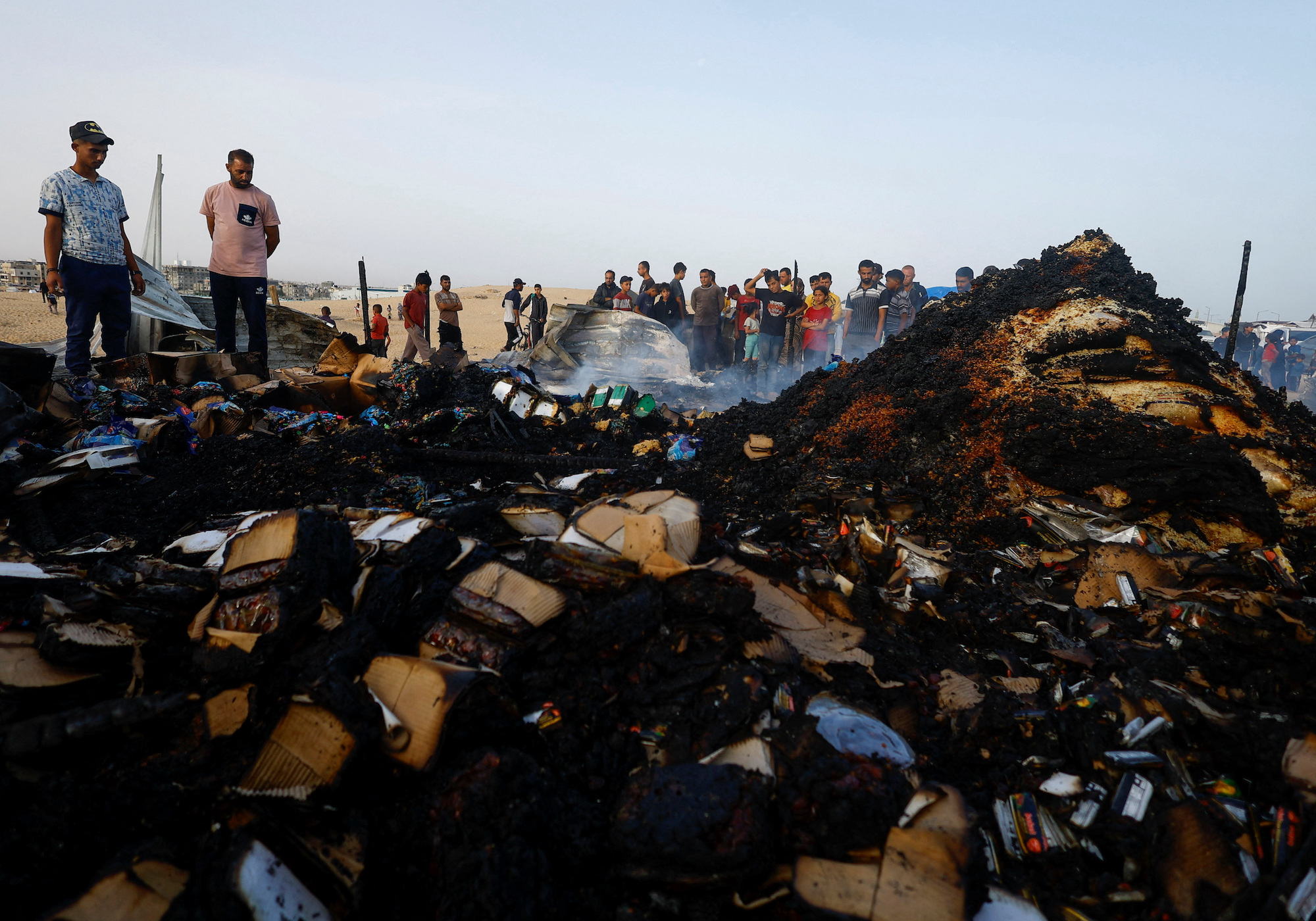 Palestinians look search among burnt debris at the site of an Israeli strike in Rafah on Monday.