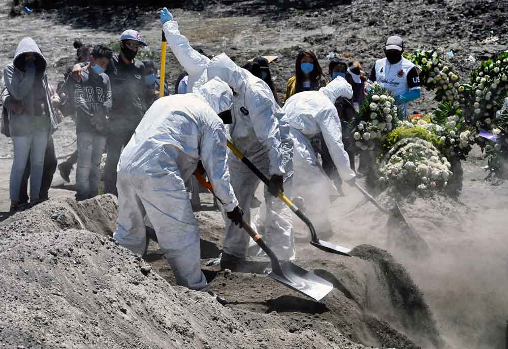 Workers bury an alleged victim of Covid-19 at the Municipal Pantheon of Valle de Chalco, Mexico, on June 4.