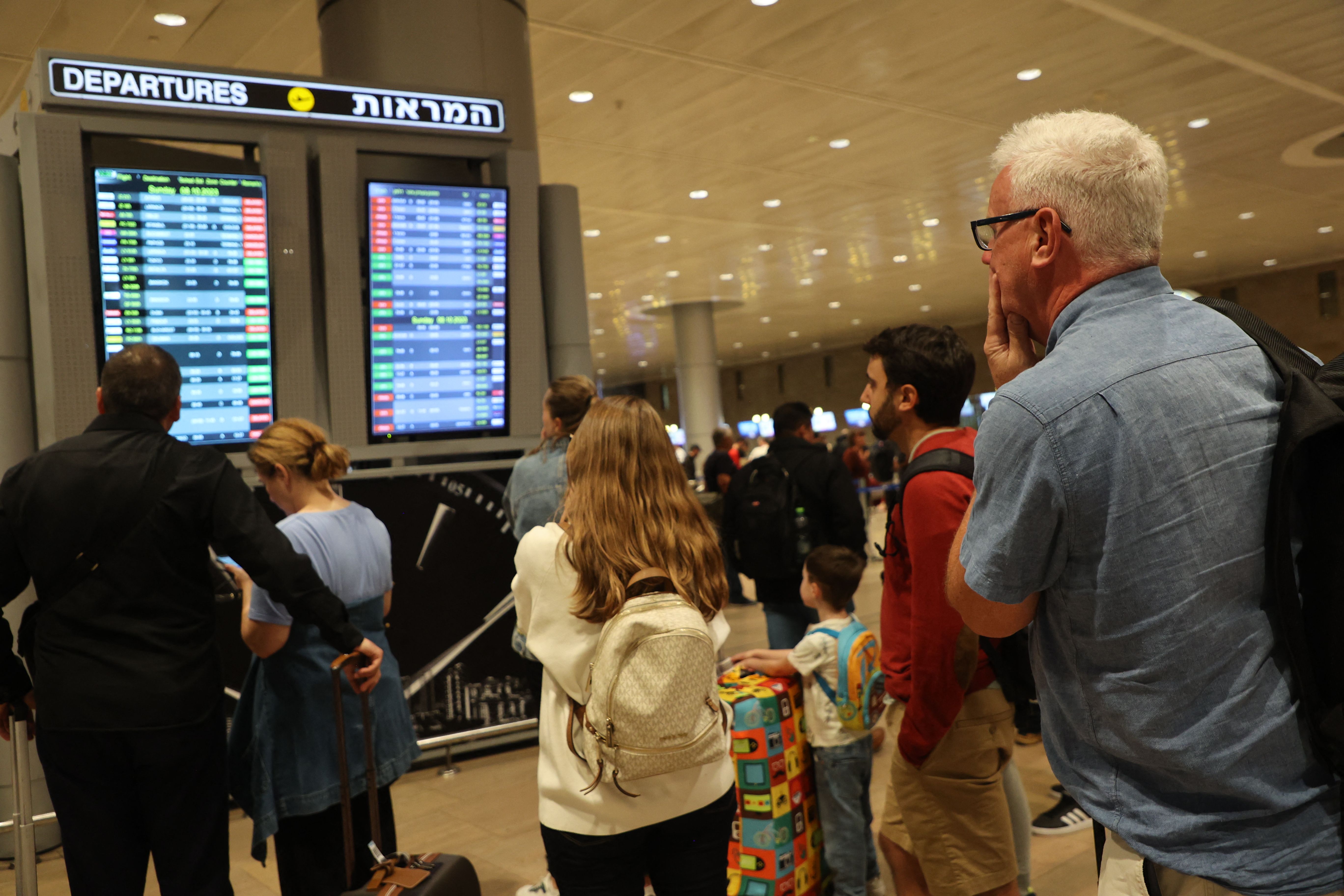Passengers look at a departure board at Ben Gurion Airport near Tel Aviv, Israel, on October 7, 2023, as flights are canceled because of the Hamas surprise attacks.