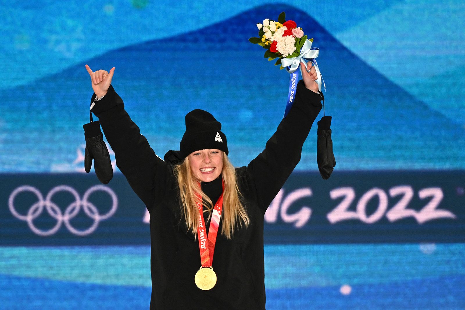New Zealand's Zoi Sadowski-Synnott celebrates on the podium after taking gold in the women's snowboard slopestyle on Sunday.