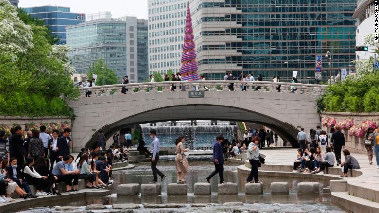 People relax at the Cheonggye Stream in the South Korean capital, Seoul, amid a lifting of restrictions in the wake of the coronavirus pandemic.
