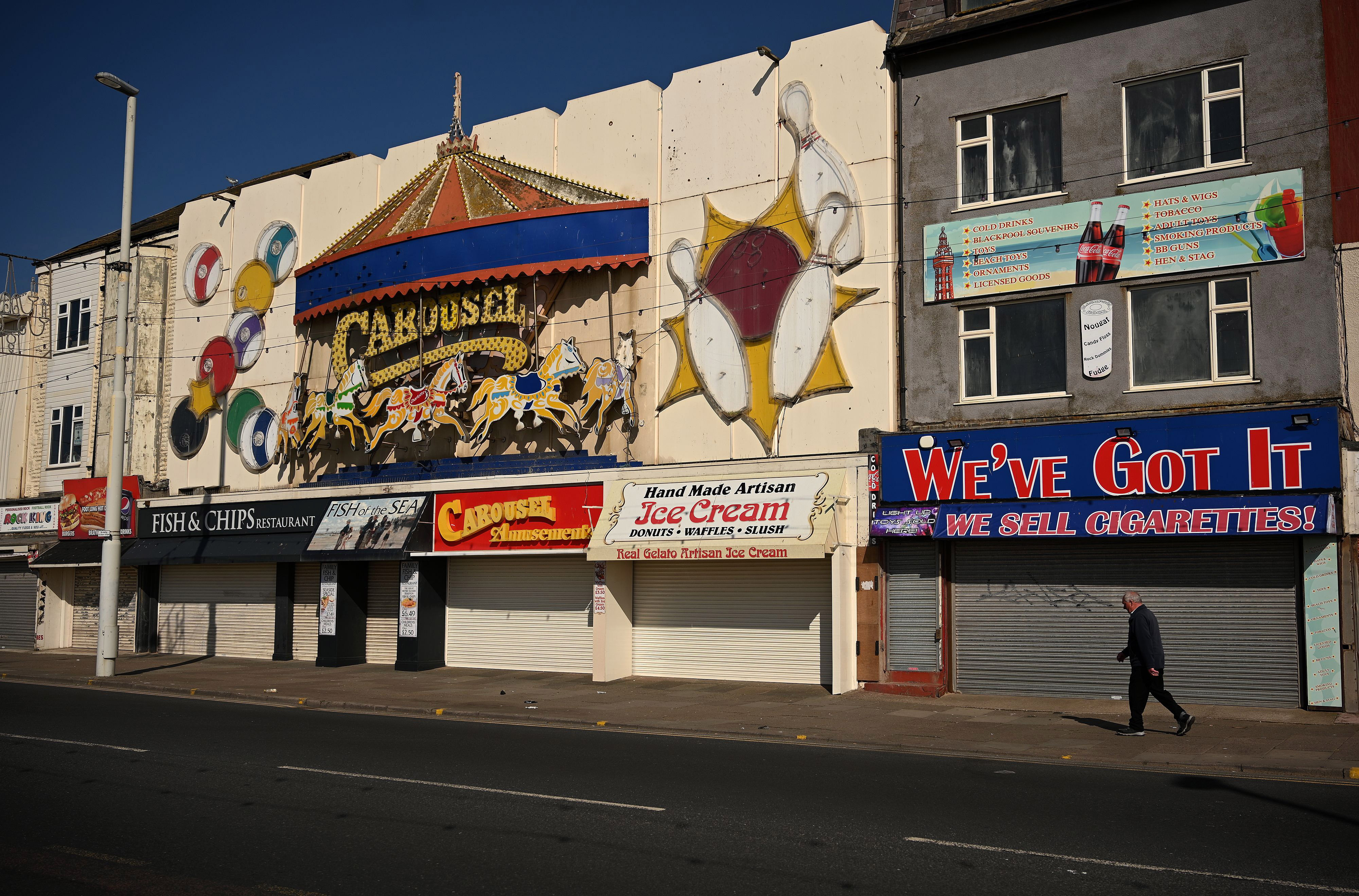 A man walks by shuttered businesses, all closed due to Covid-19 restrictions, in Blackpool, England, on April 13.