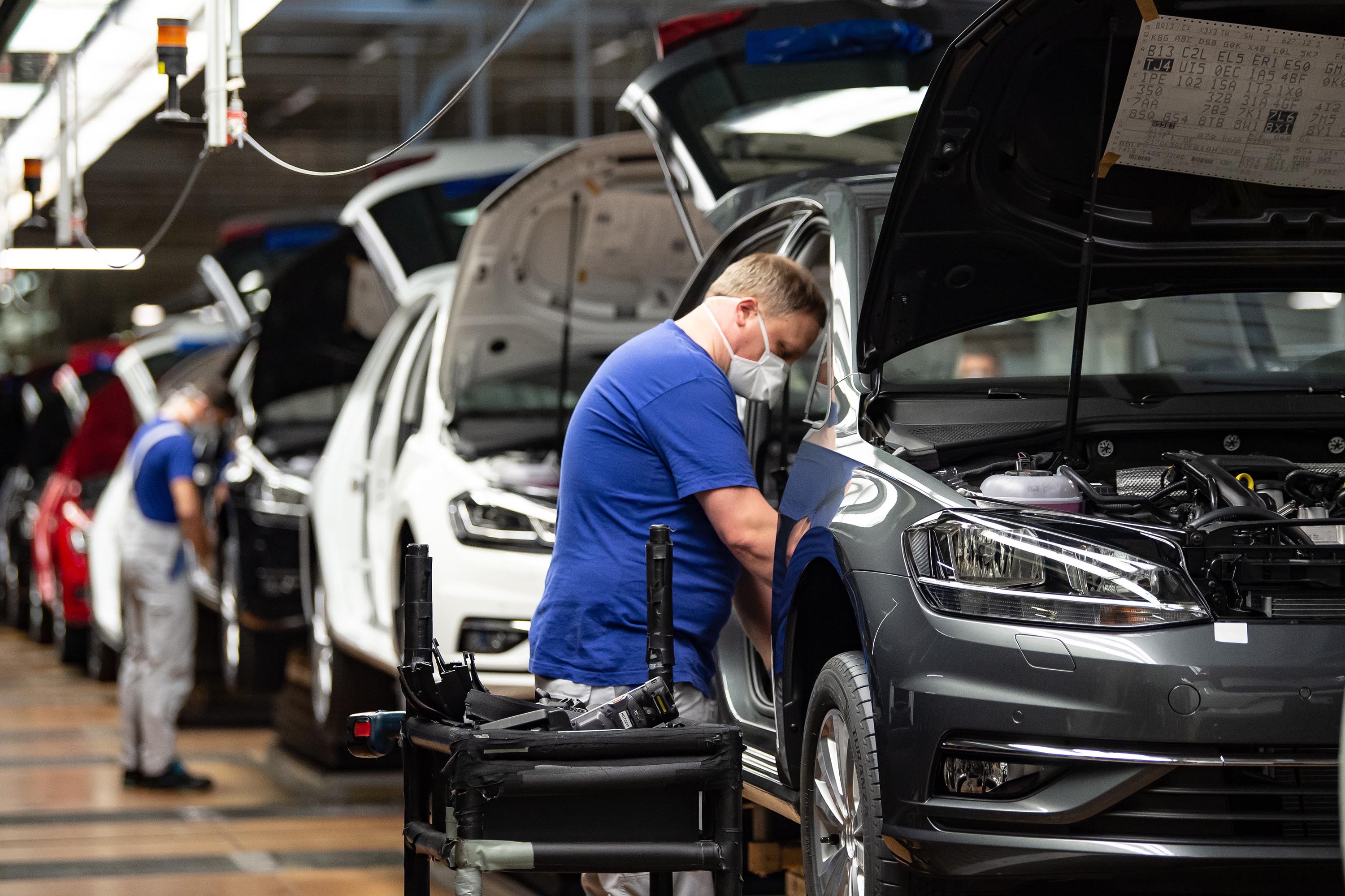 An employee works on a production line after Volkswagen's Wolfsburg Plant reopened on April 27, in Wolfsburg, Germany.