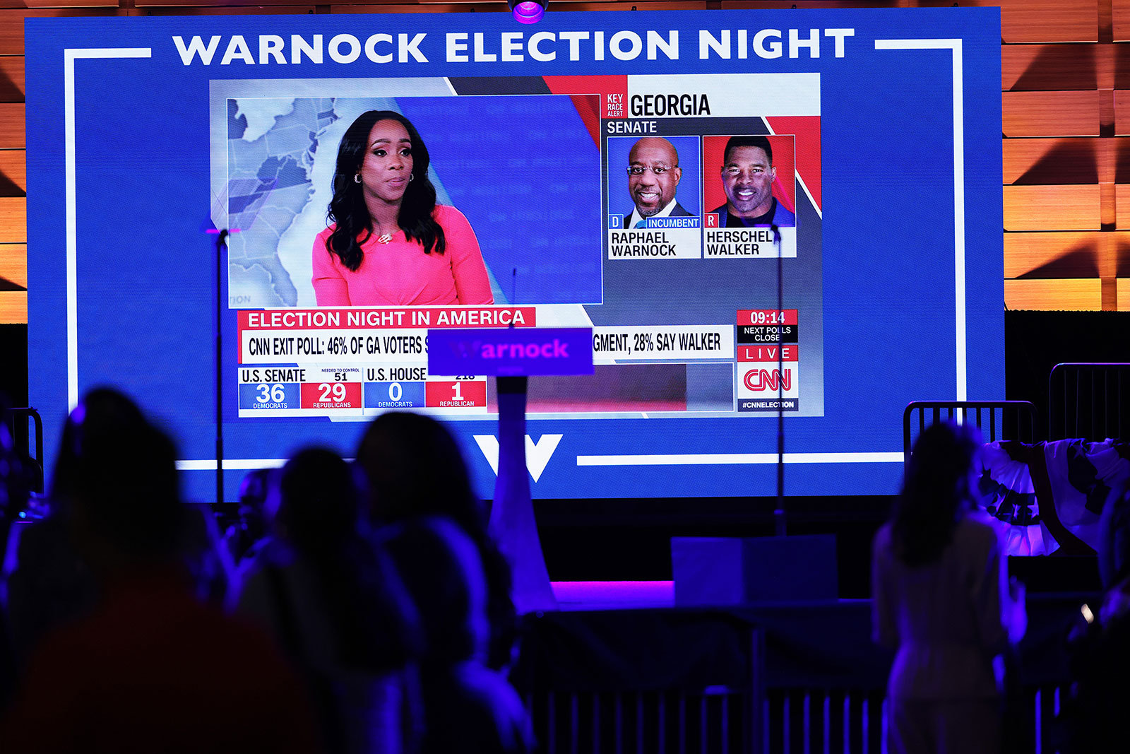 Exit polls are reported on a screen at an election night event for Raphael Warnock in Atlanta on Tuesday.