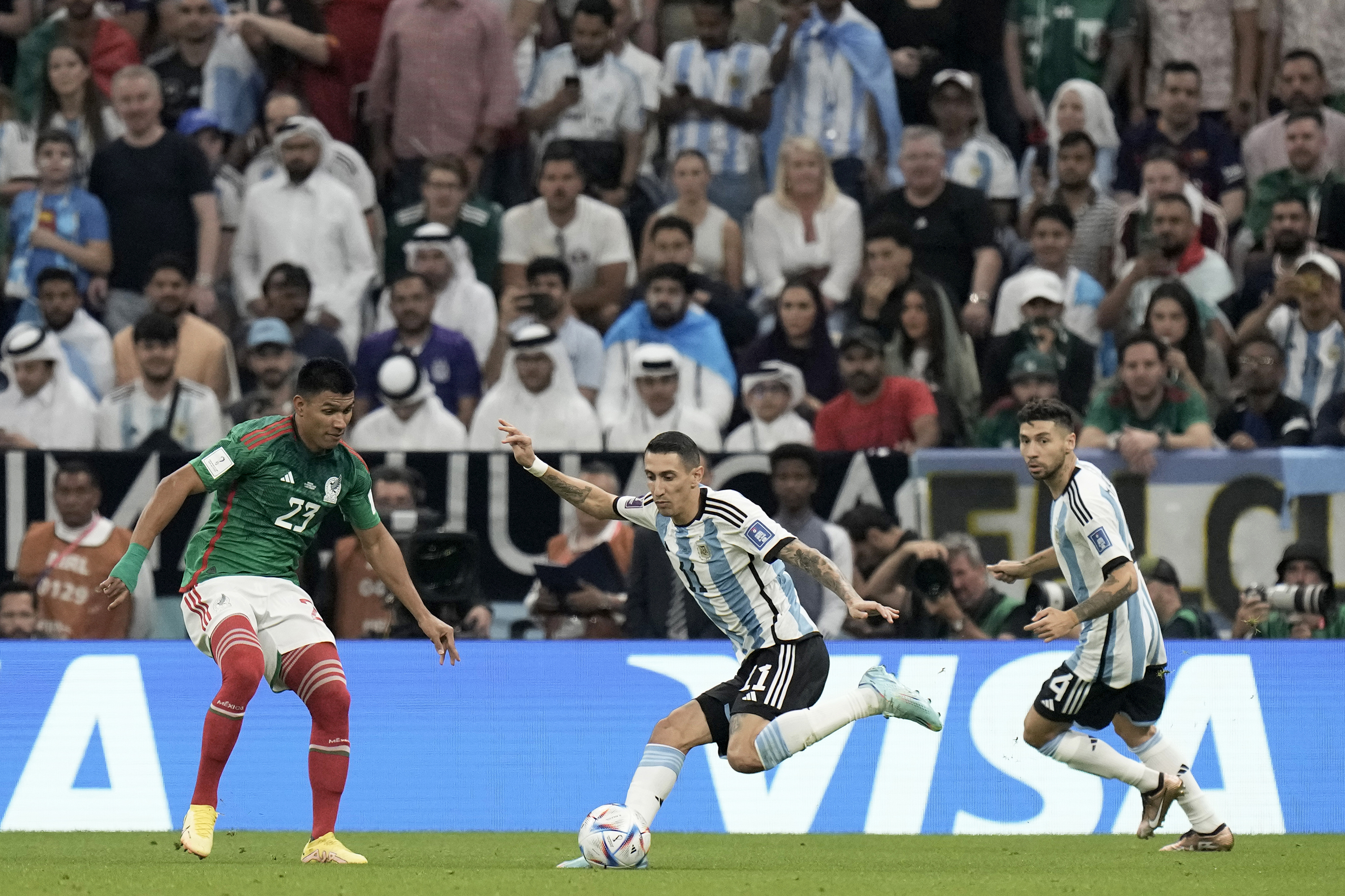 Argentina's Angel Di Maria, center, controls the ball next to Mexico's Jesus Gallardo, left, during the World Cup group C soccer match between Argentina and Mexico, at the Lusail Stadium in Lusail, Qatar, on Saturday.