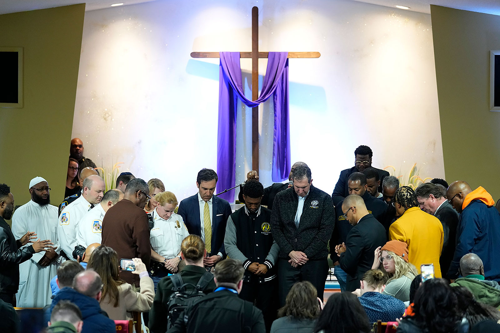 Officials including Baltimore Mayor Brandon Scott, center, pray during a vigil at Mount Olive Baptist Church in Dundalk, Maryland., on Tuesday, March 26.
