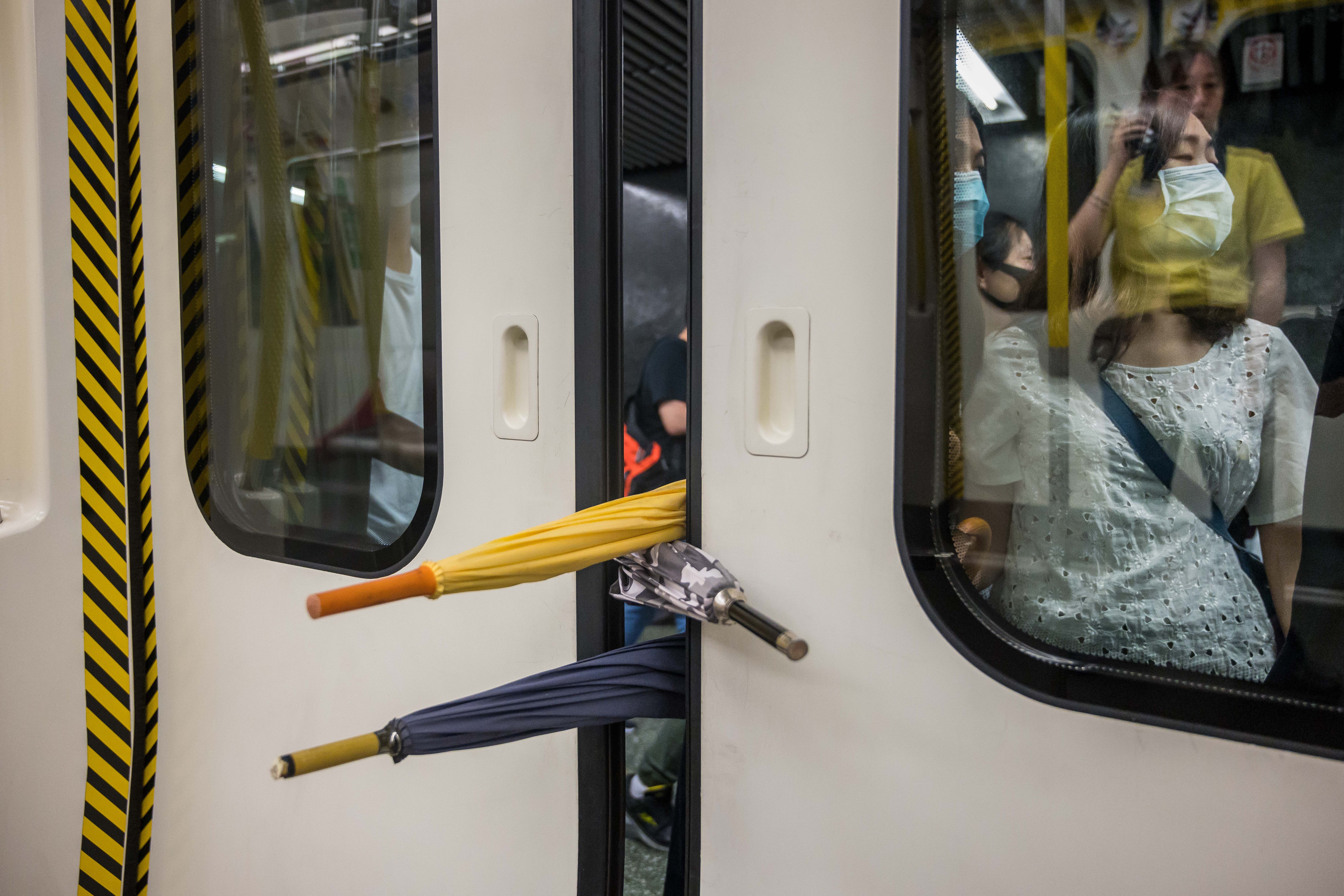 A group of protesters prevent the doors of a train from closing on August 5, 2019 in Hong Kong.