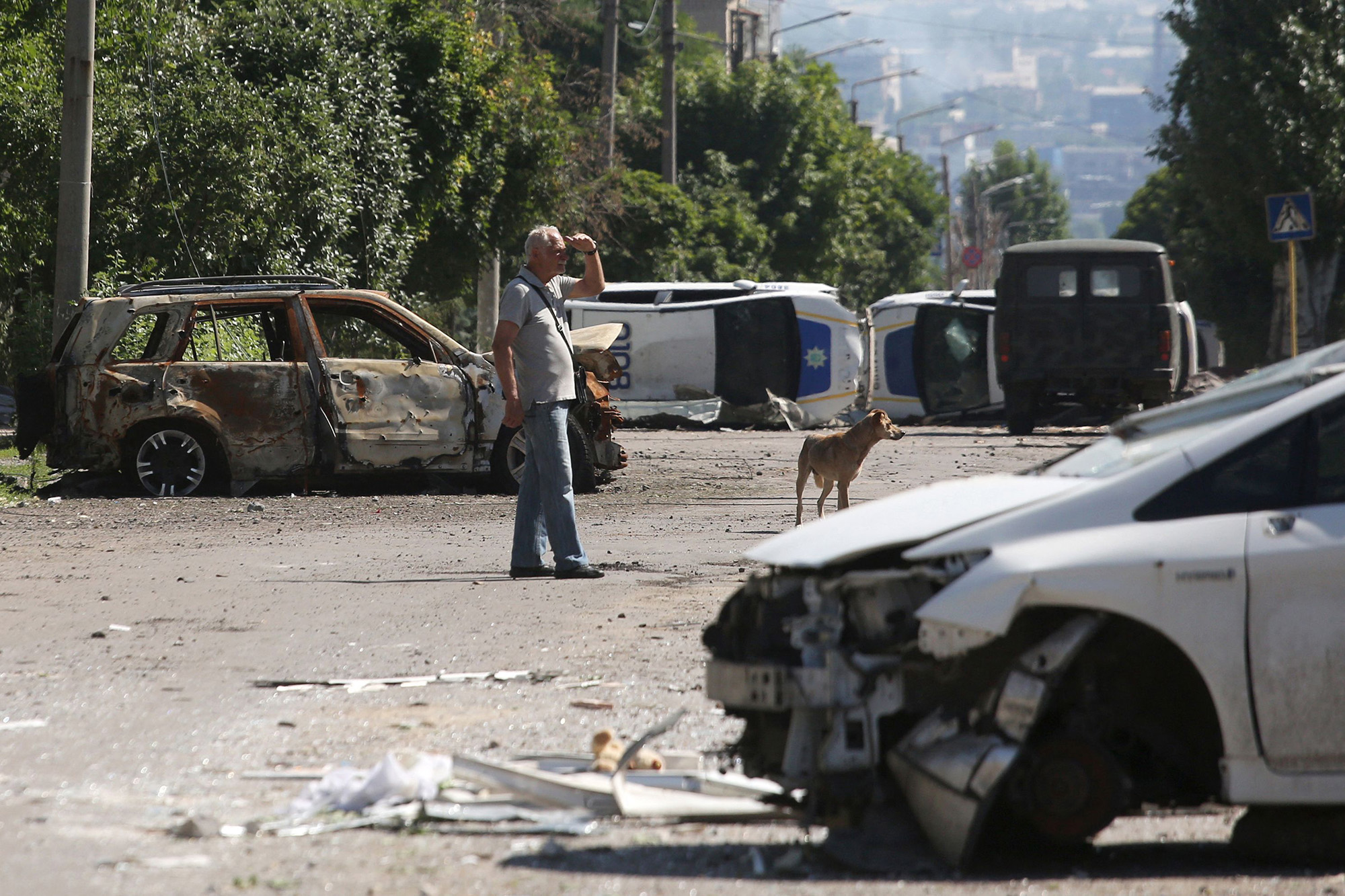 A man stands by a barricade made with destroyed police cars in Lysychansk, Ukraine, on June 21.