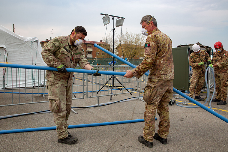 Members of the military aid with the construction of a field hospital, run by non-governmental organisation Samaritans Purse, in a parking lot in Cremona, Italy, on Friday, March 20.