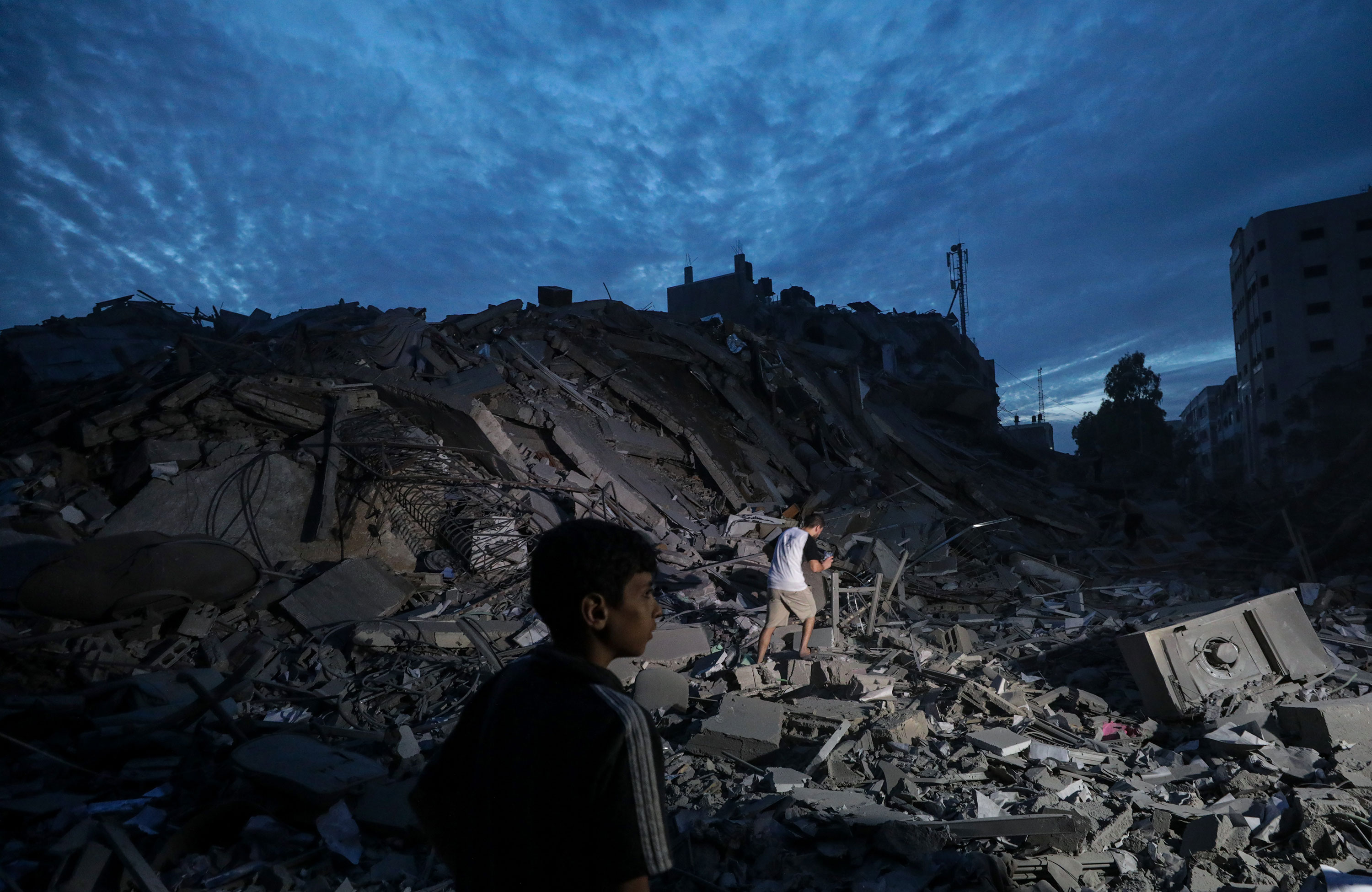 People inspect the destroyed surroundings of the Palestine Tower in Gaza City after Israeli warplanes targeted it October 7. 