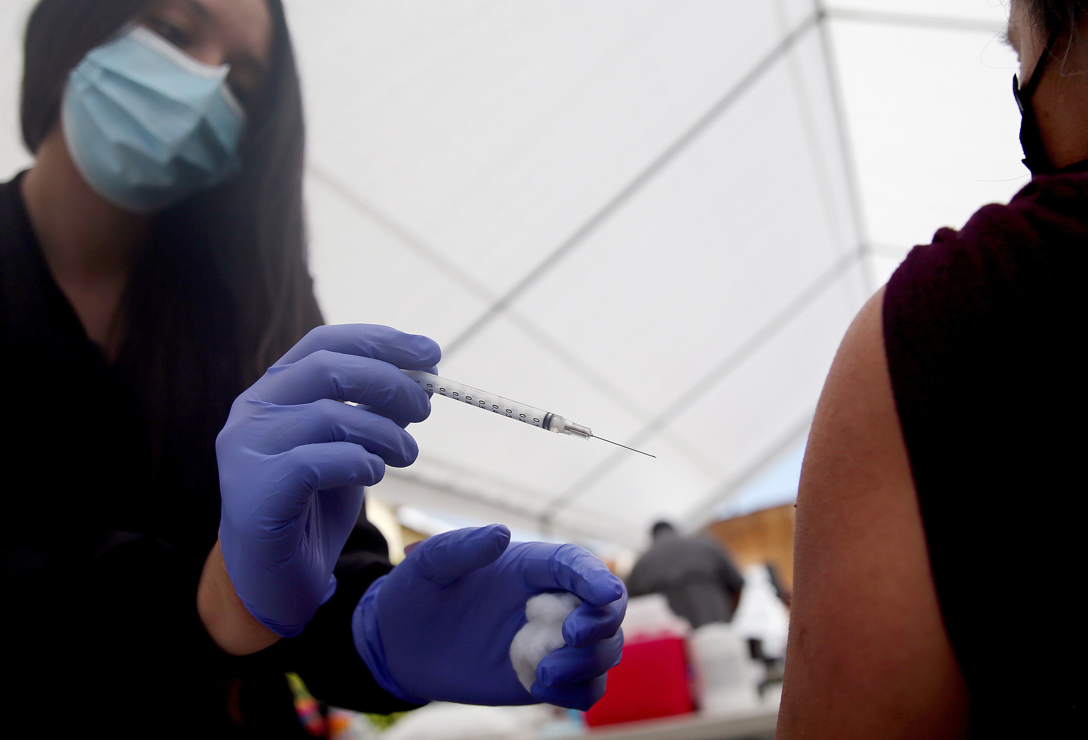 A health care worker administers a dose of the Pfizer COVID-19 vaccine at a clinic targeting Central American Indigenous residents at CIELO, an Indigenous rights organization, on April 10 in Los Angeles.