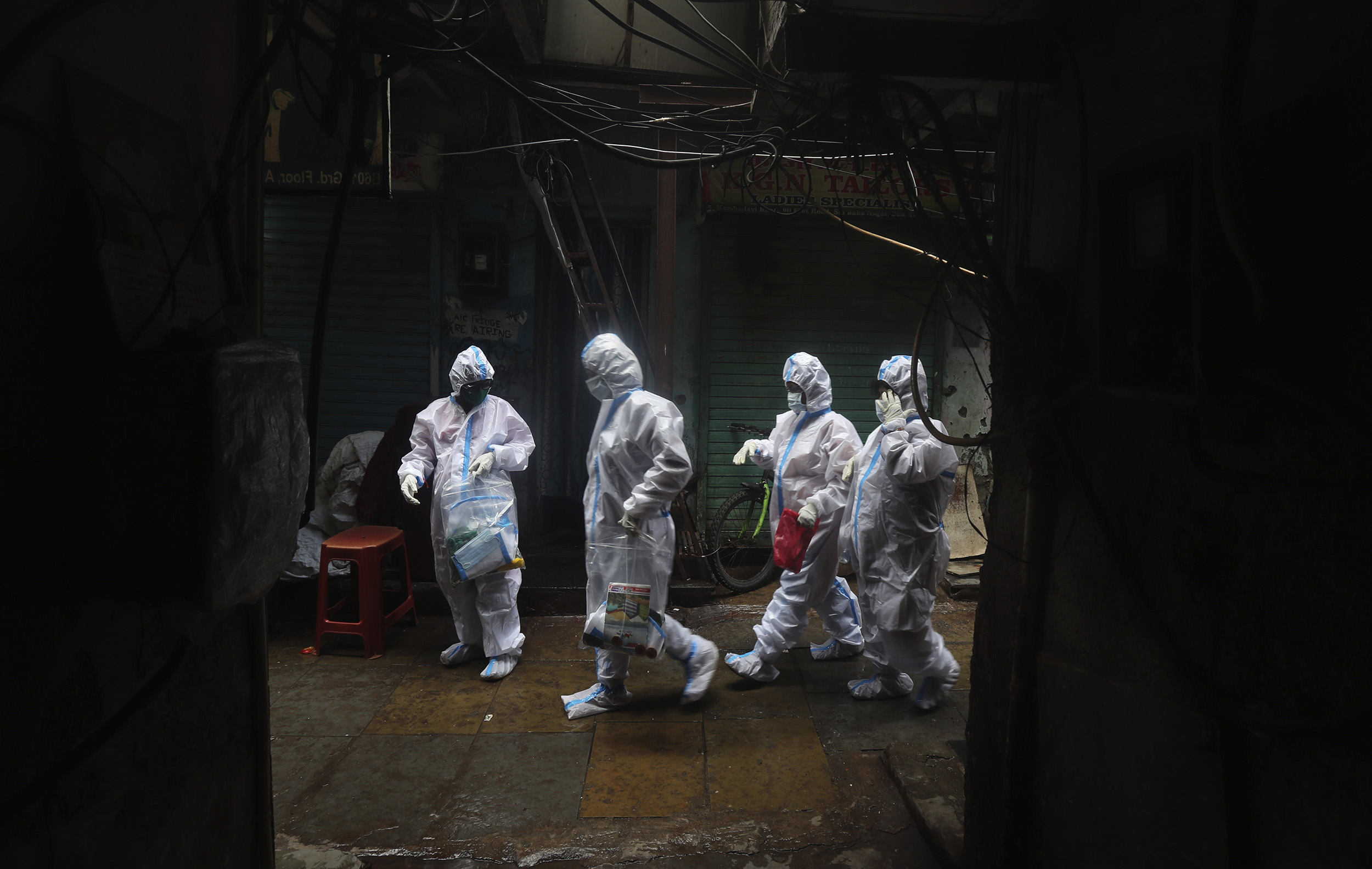 Health workers walk to screen residents for Covid-19 symptoms in Dharavi, one of Asia's biggest slums, on August 3, in Mumbai, India. 