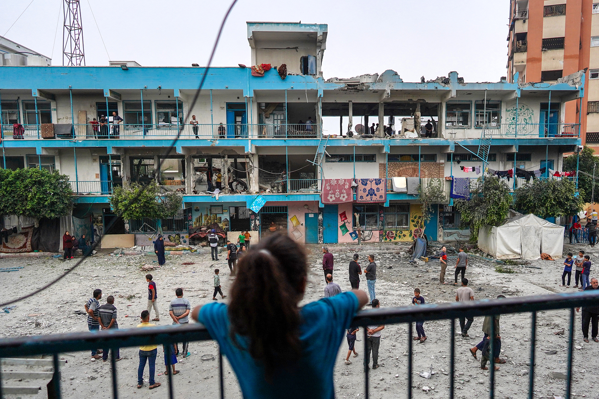 A Palestinian girl watches over a UN-school housing displaced people that was hit by Israeli bombardment in Nuseirat, Gaza, on June 6.