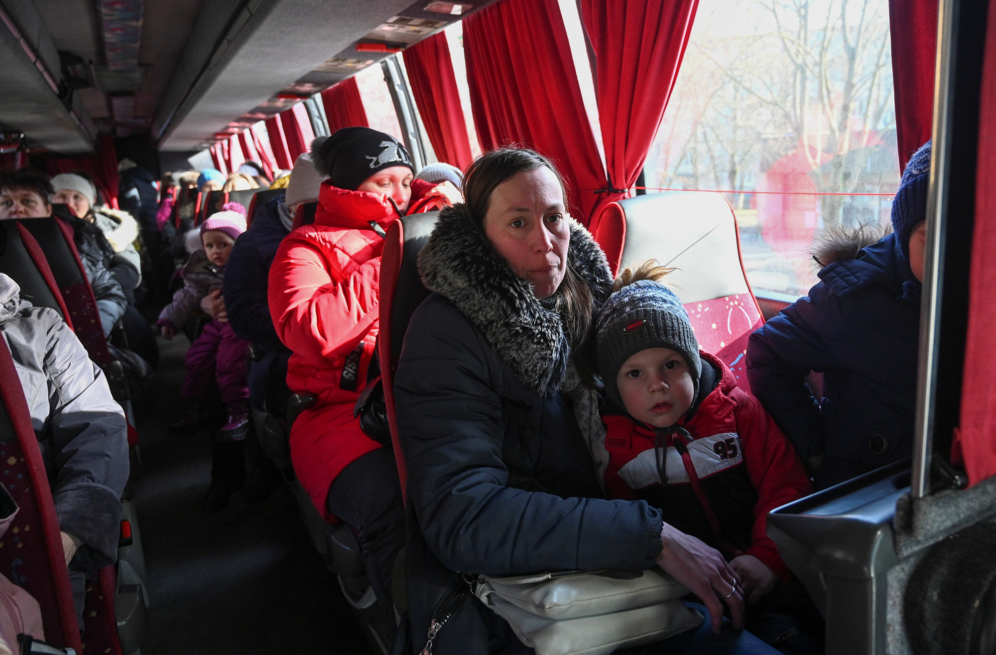 Ukrainians who have been evacuated from separatist-controlled regions in eastern Ukraine sit in a bus as they arrive at a railway station in the Rostov region, Russia, on February 20.