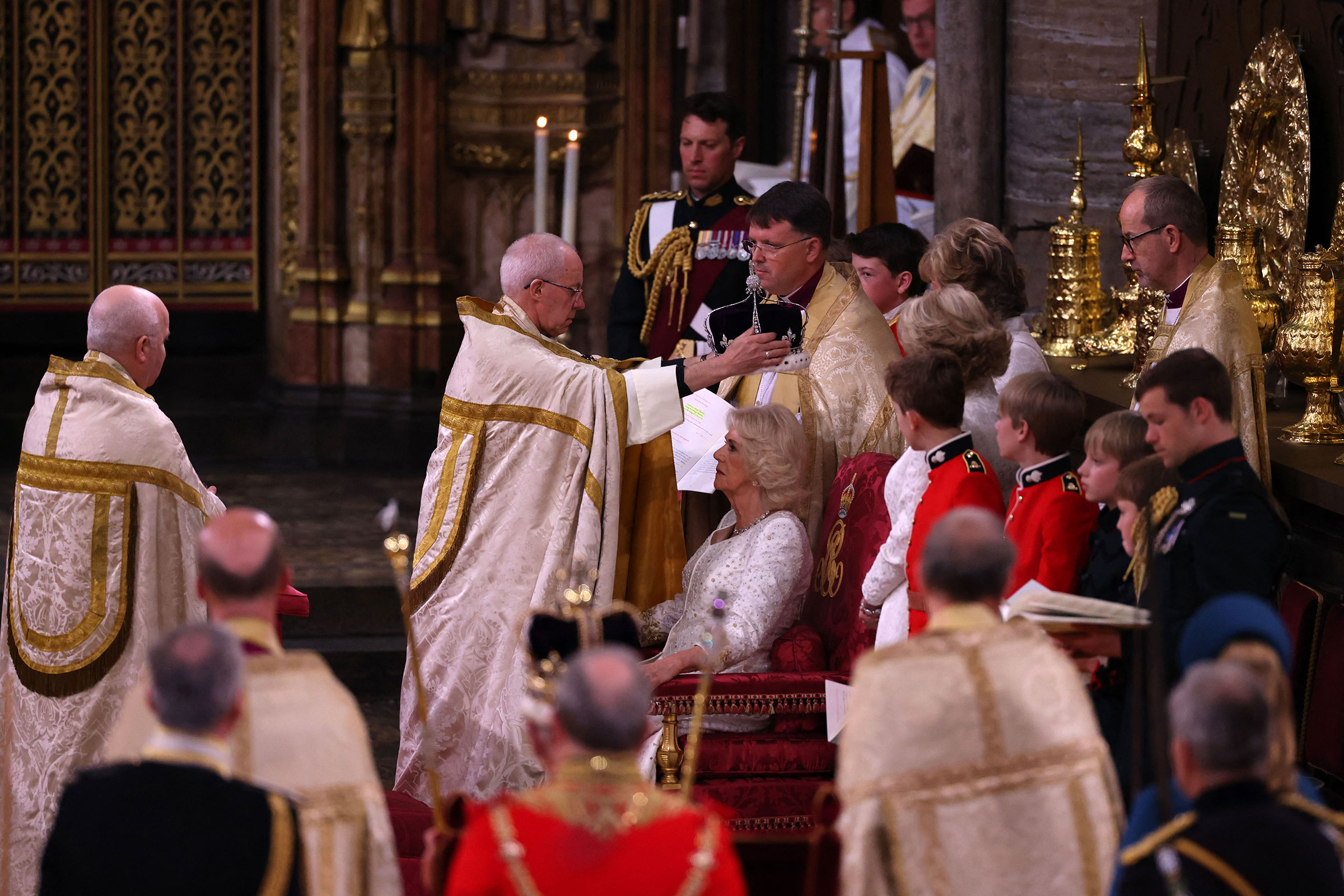 The Archbishop of Canterbury Justin Welby places a modified version of Queen Mary's Crown onto Queen Camilla's head.