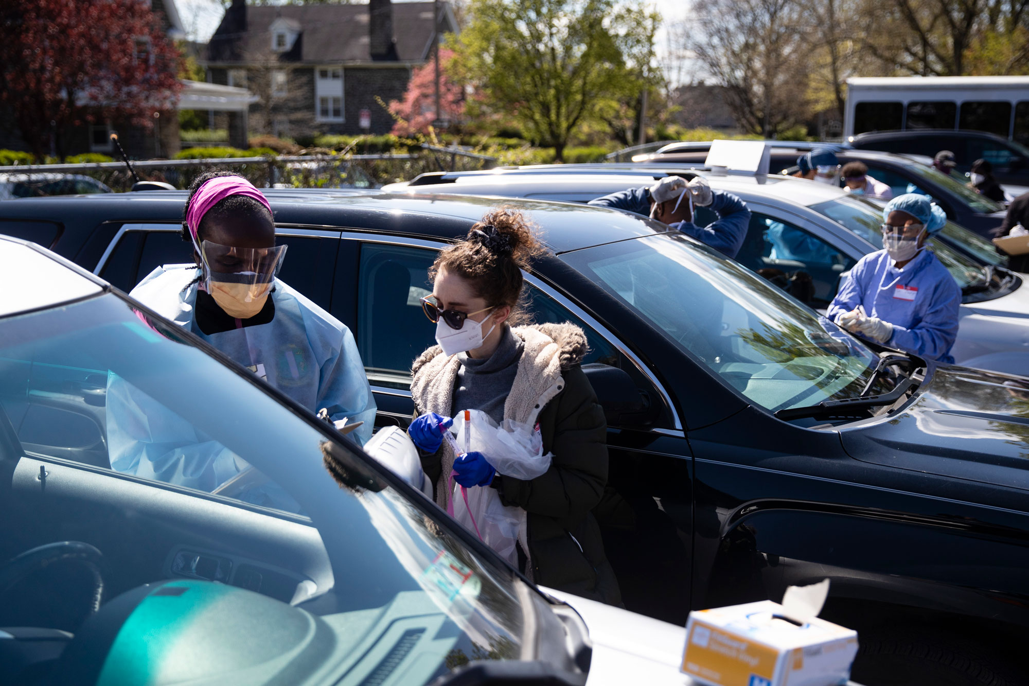 Dr. Ala Stanford, left, assisted by medical student Tal Lee, prepares to administer a COVID-19 swab test on a person in the parking lot of Pinn Memorial Baptist Church in Philadelphia, on April 22.