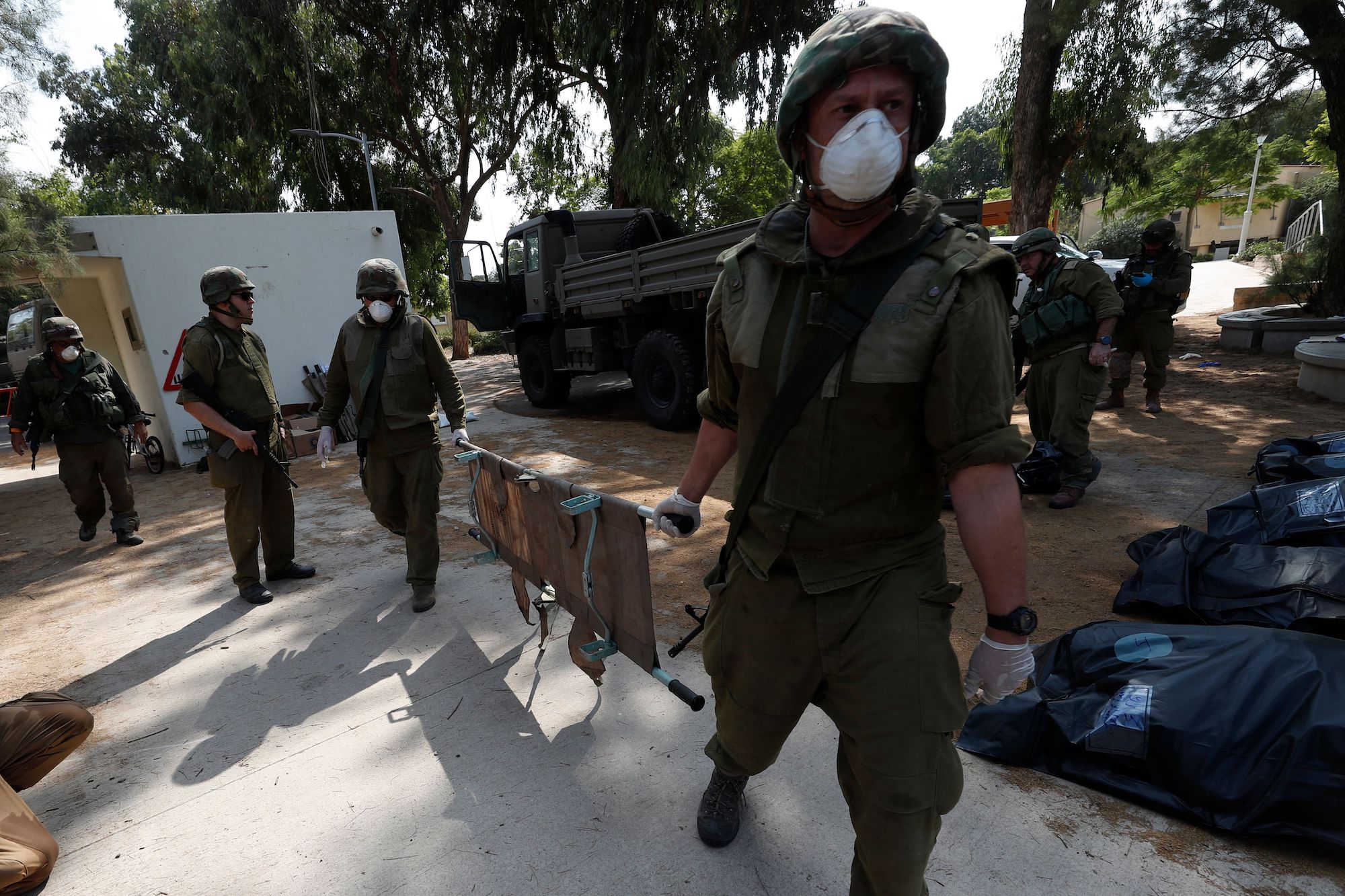 IDF soldiers move the bodies of Israelis killed in the Kfar Aza kibbutz, near the border with Gaza, on Tuesday.
