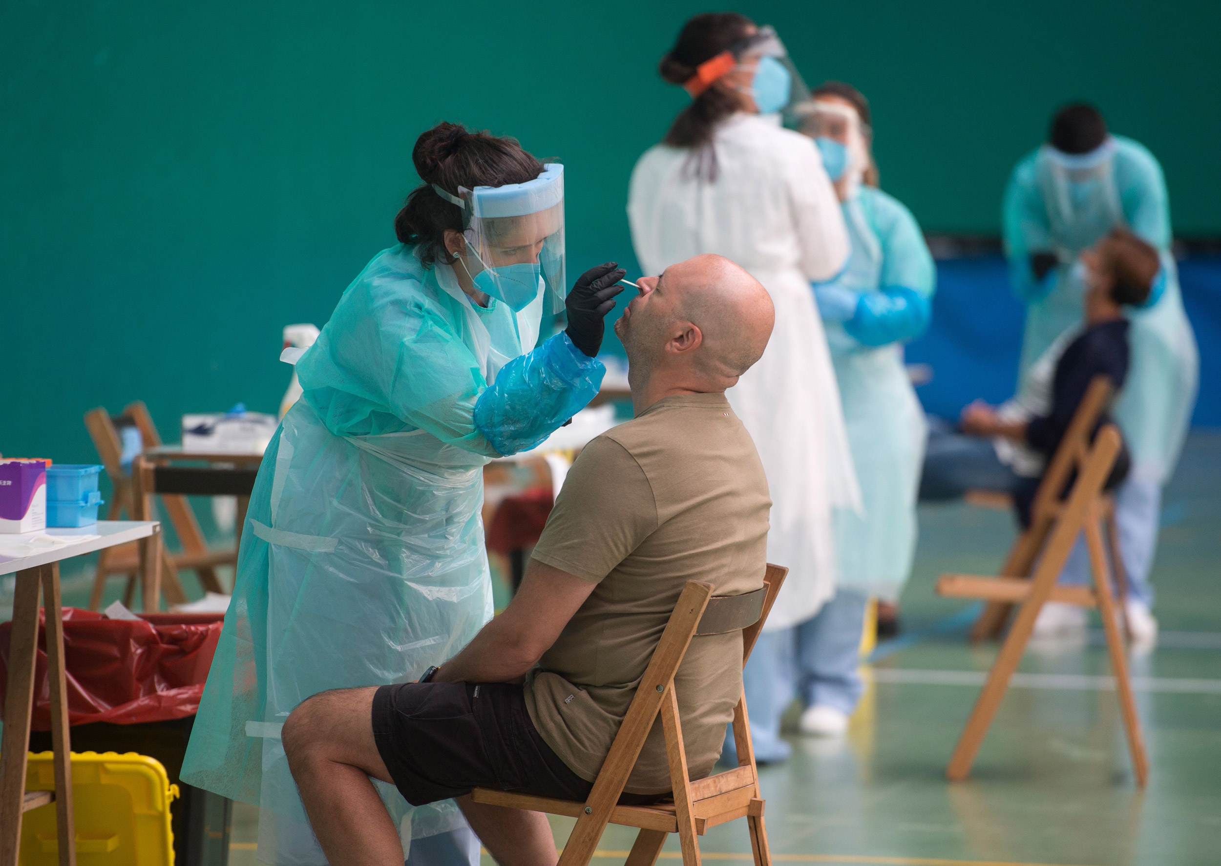 A healthcare worker uses a swab to collect a sample at a temporary testing center for coronavirus in the Spanish Basque city of Getaria on July 15.