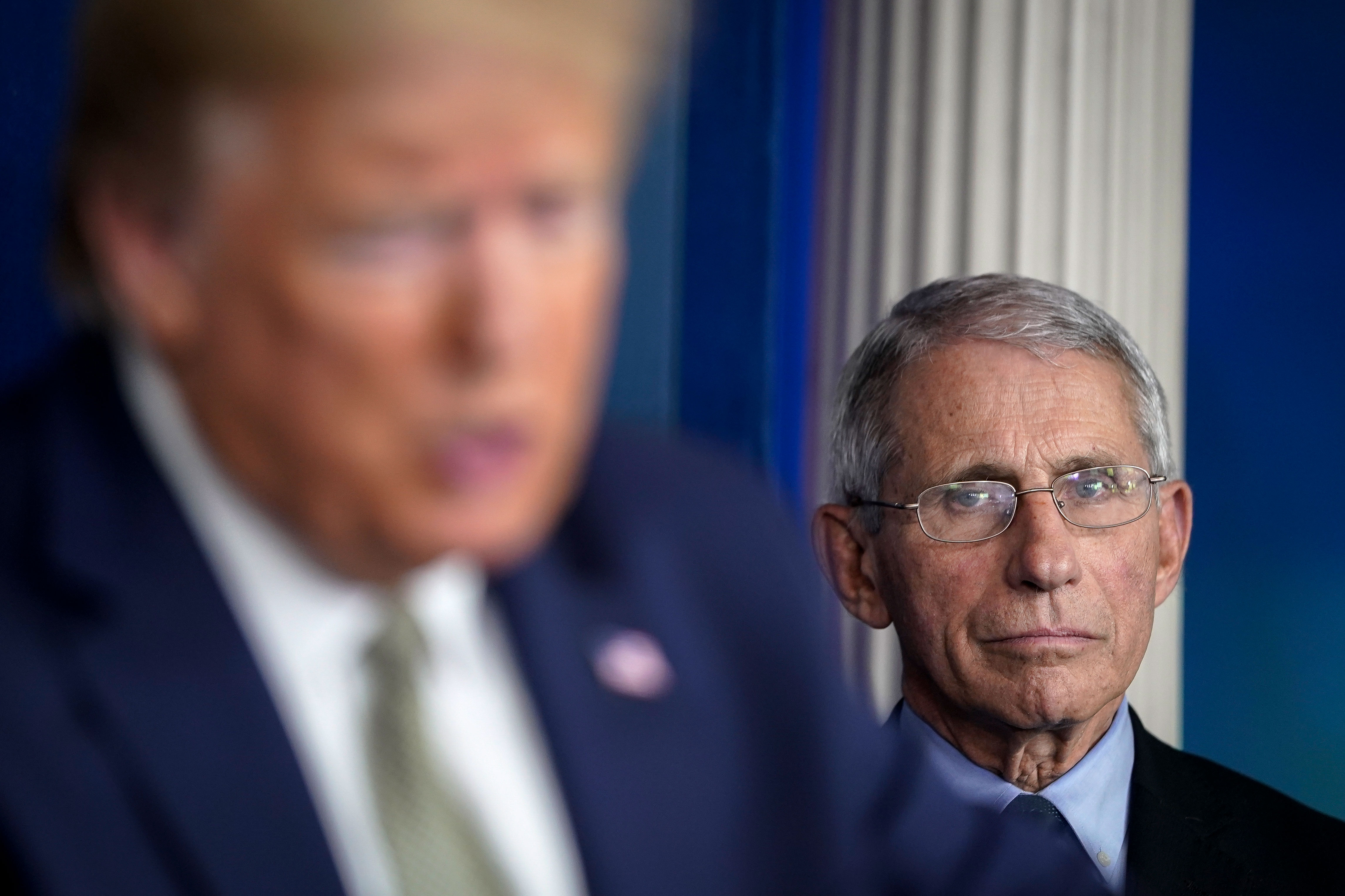 Dr. Anthony Fauci listens to President Donald Trump during a Covid-19 press conference at the White House on March 17.