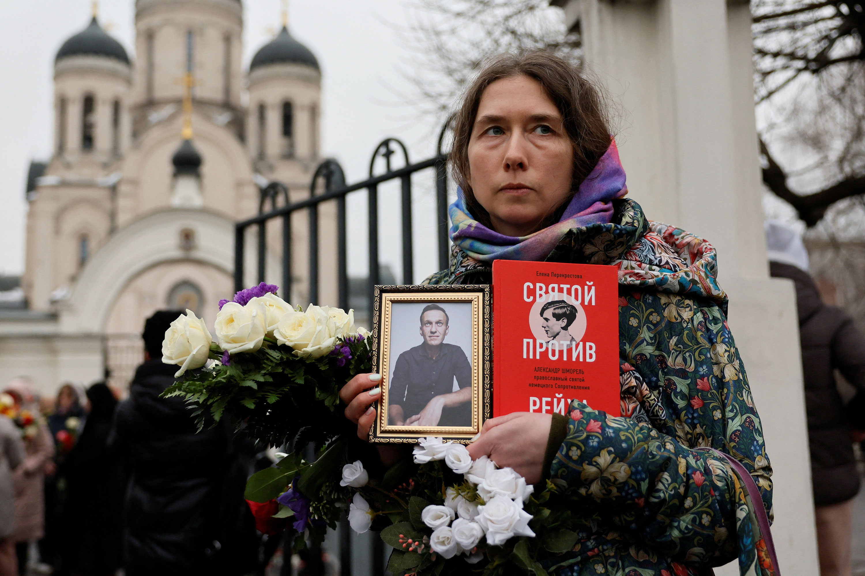 A person holds Navalny's portrait outside the church after the funeral service.