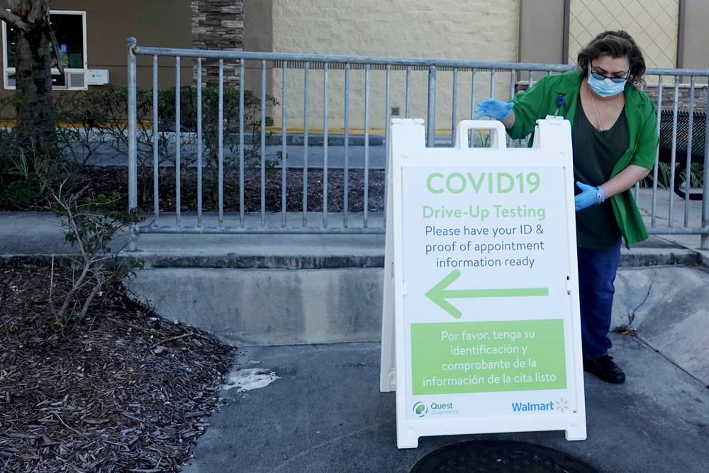 Lisa Wiley, of Walmart, sets up for the opening at a new drive-up self-administered Covid-19 testing site run by Quest Diagnostics at the Walmart store in Boynton Beach, Florida, on Tuesday, June 16.