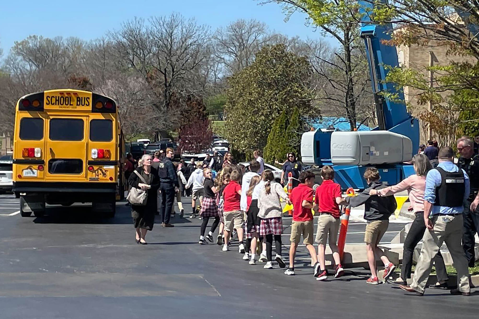 Children from the Covenant School hold hands as they are taken to a reunification site following a deadly shooting at their school in Nashville, Tennessee, on Monday, March 27.