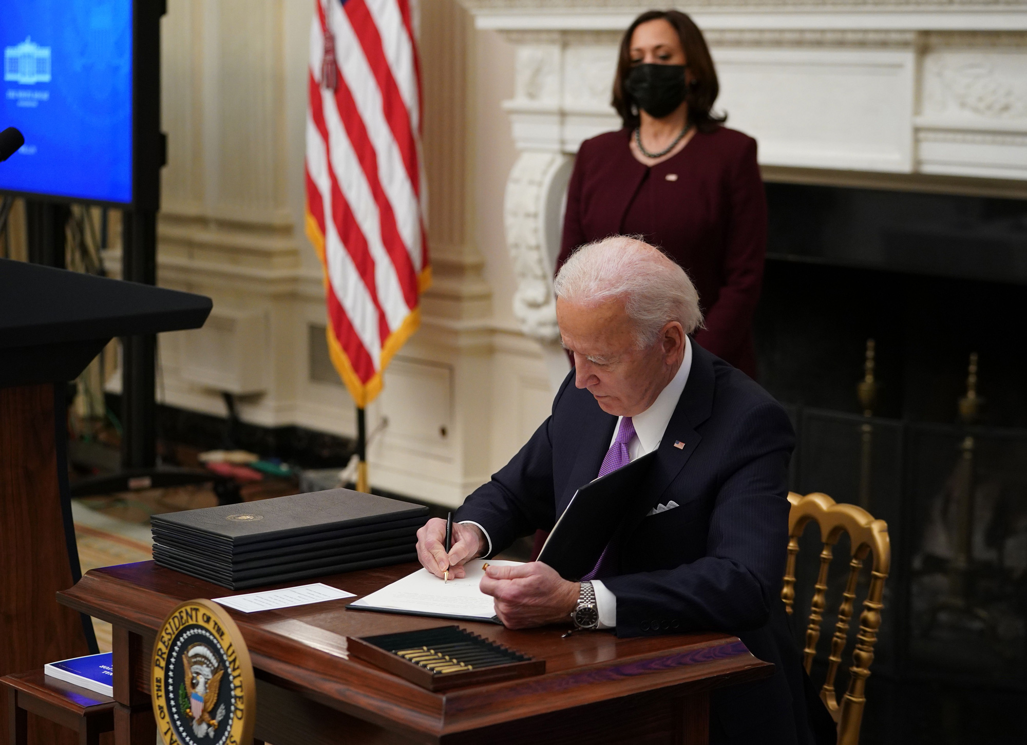 President Joe Biden signs an executive order promoting safe travel as part of the Covid-19 response in the State Dining Room of the White House in Washington, DC, on January 21.