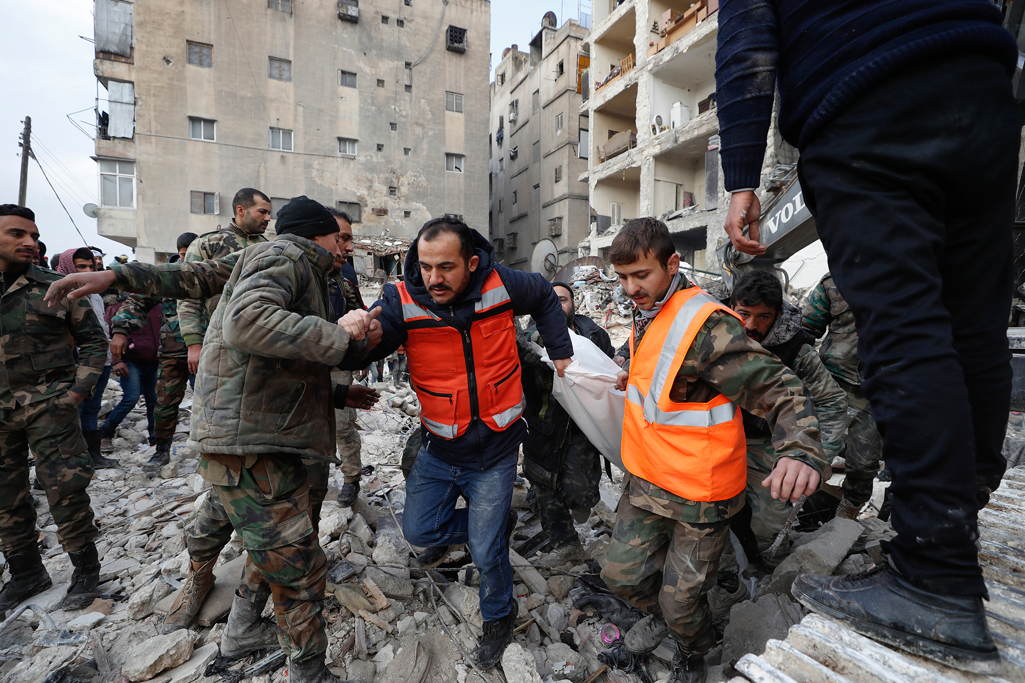 Rescue teams carry the body of a victim from a destroyed building in Aleppo, Syria, on Tuesday, February 7.