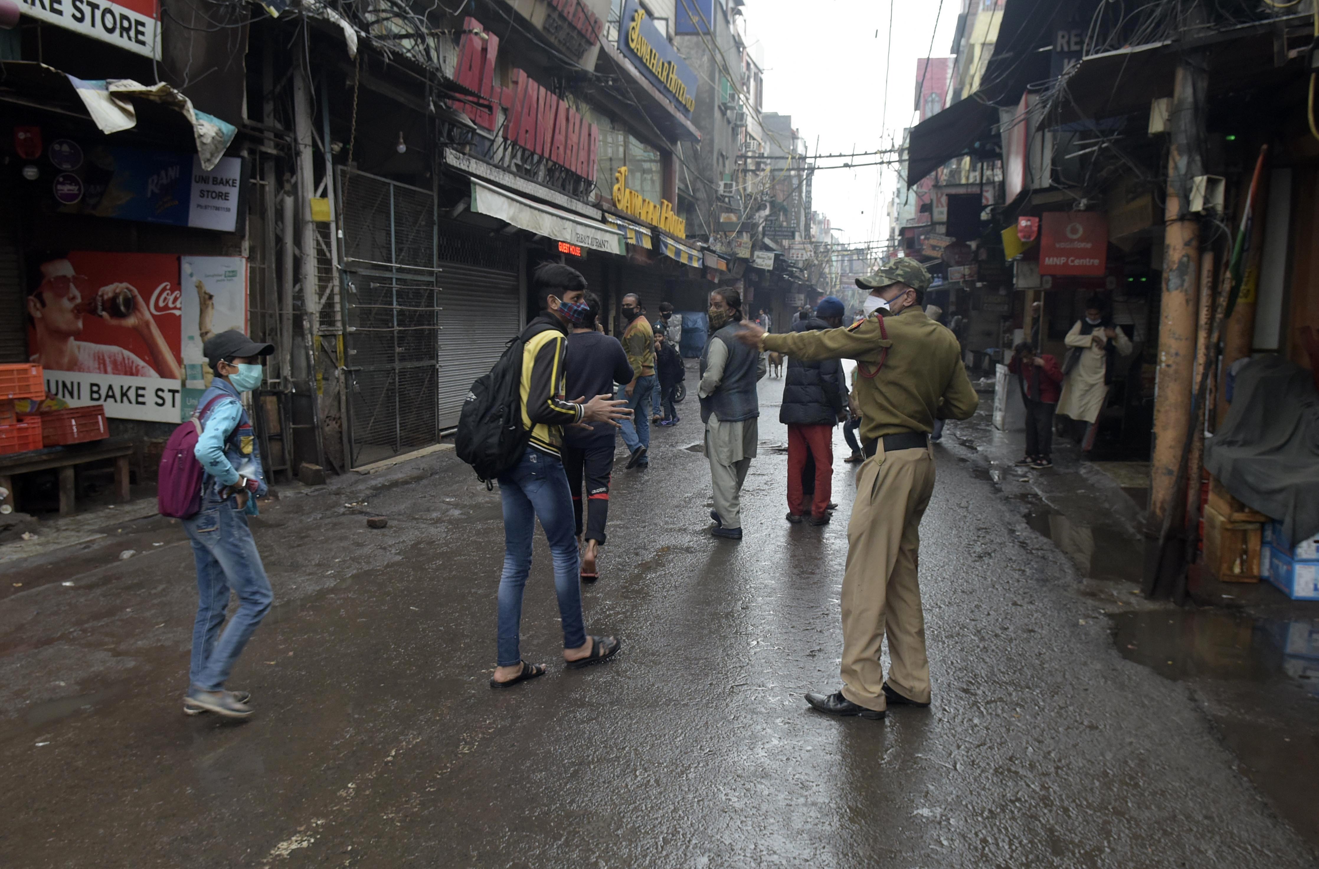A policeman directs pedestrians to return home during weekend curfew imposed to curb the spread of the coronavirus in New Delhi, India, on Saturday.