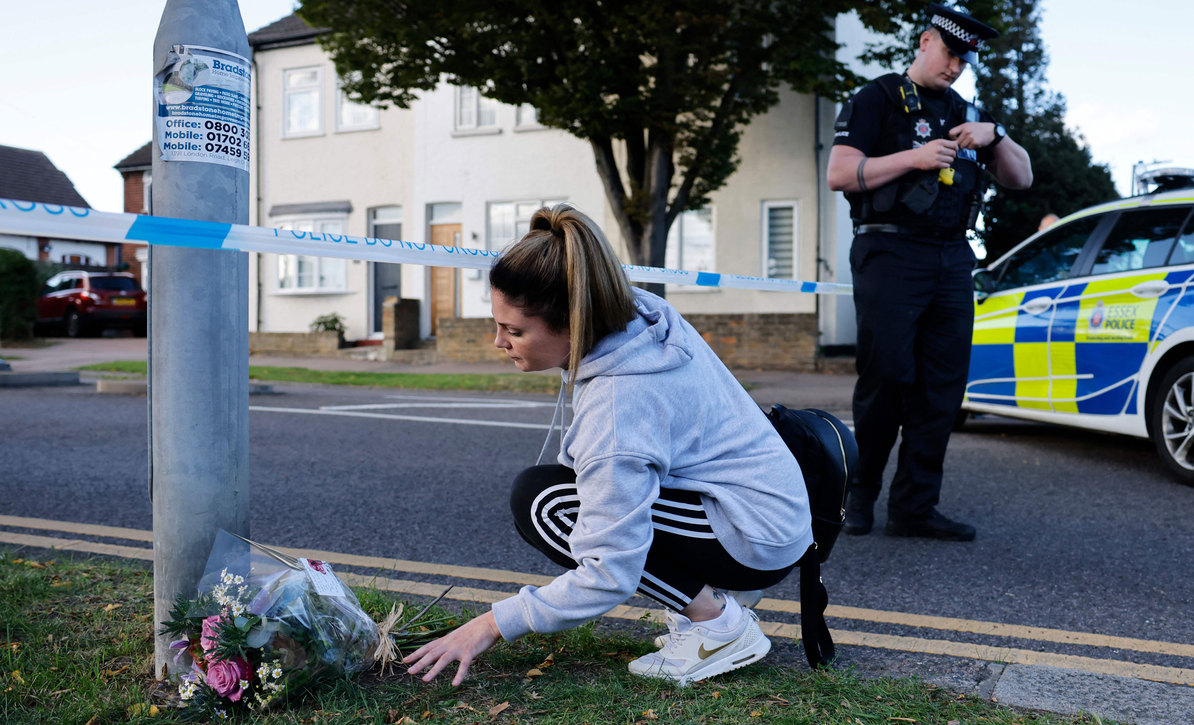 A woman leaves flowers at a police cordon near the scene.
