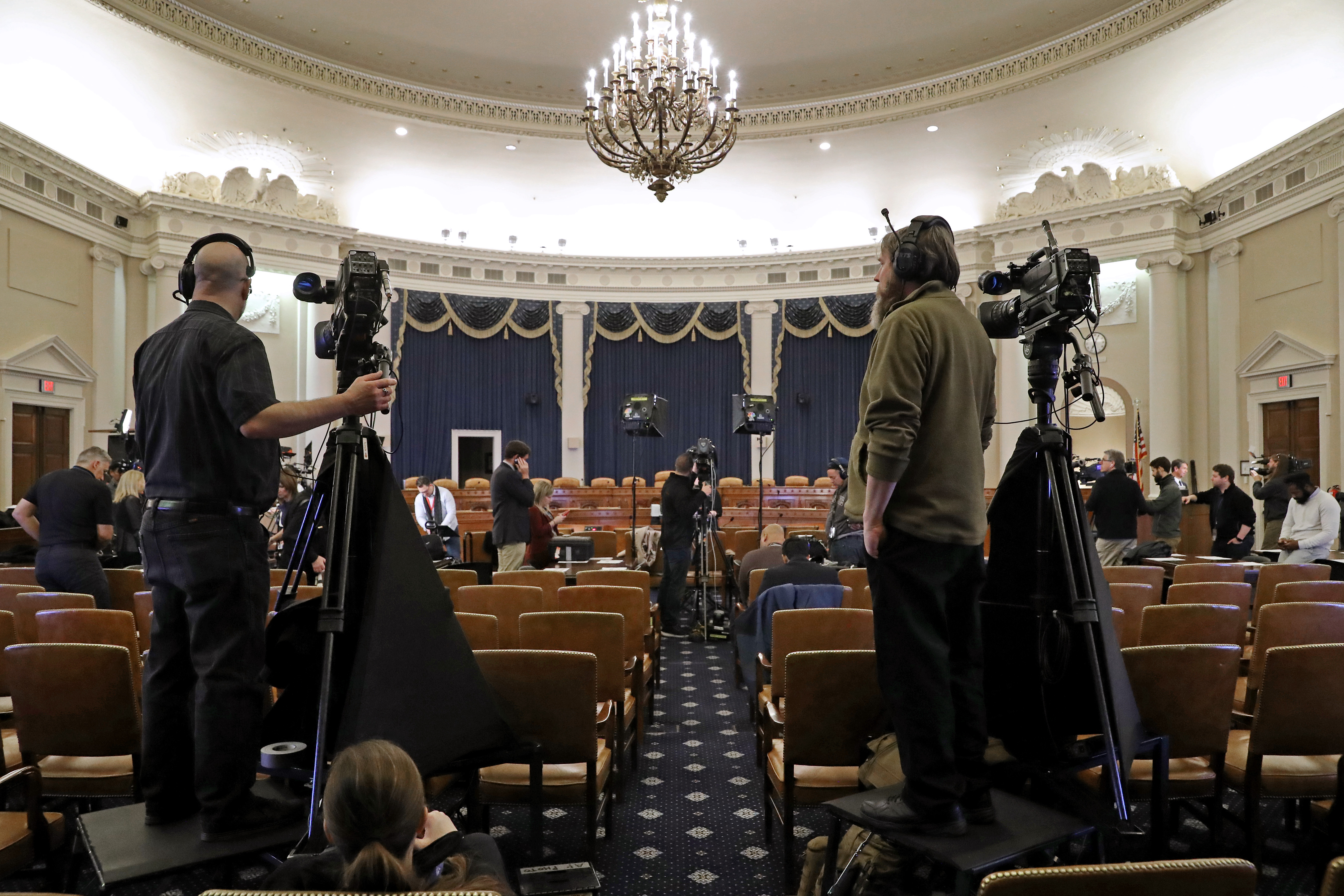 Journalists and camera crews report from inside the hearing room where the House Intelligence Committee will hold its first public impeachment hearing (Photo by Chip Somodevilla/Getty Images)