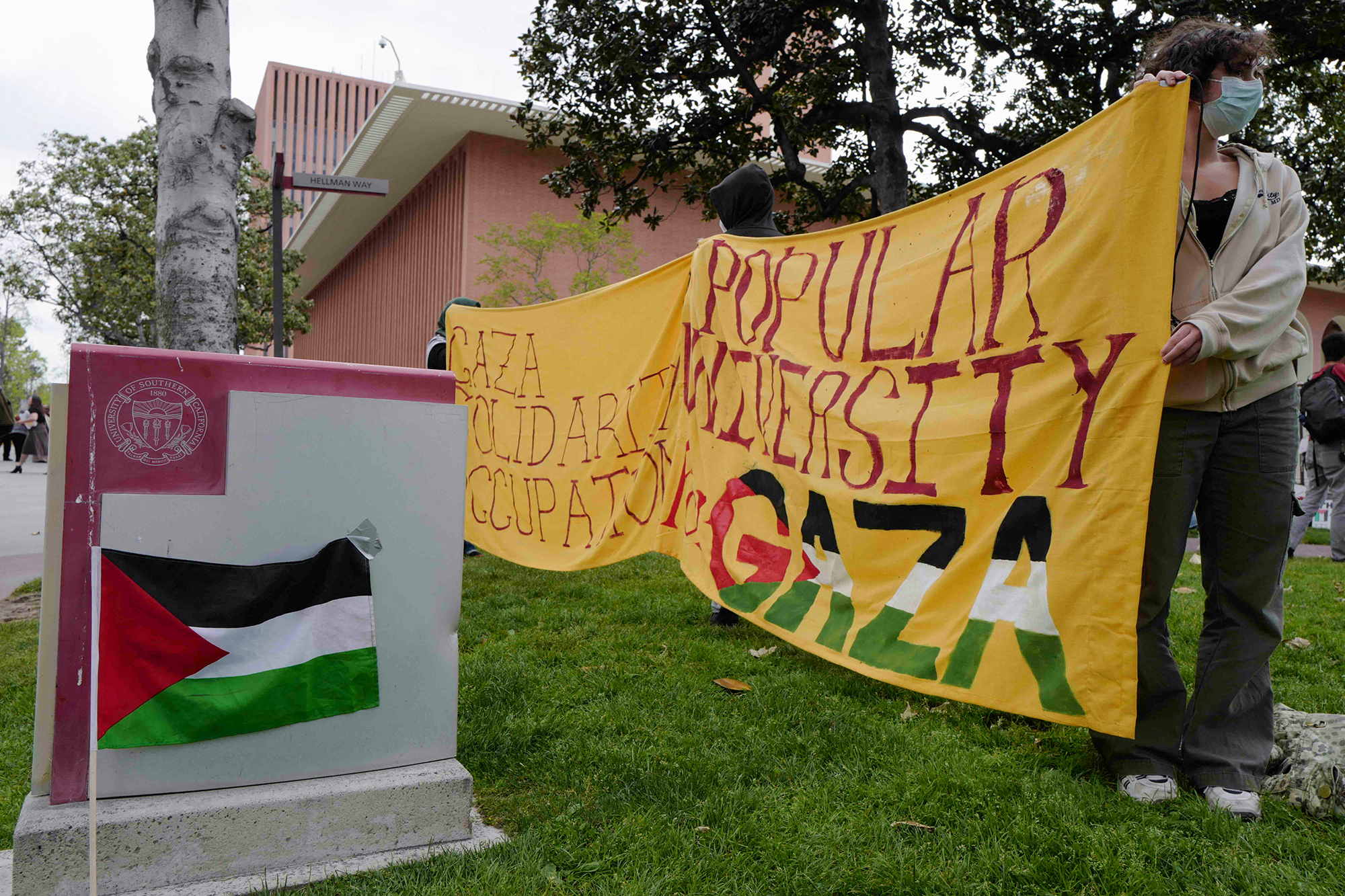 People hold a banner as students build a protest encampment in support of Palestinians, at the University of Southern California's Alumni Park in Los Angeles, California, on April 24.