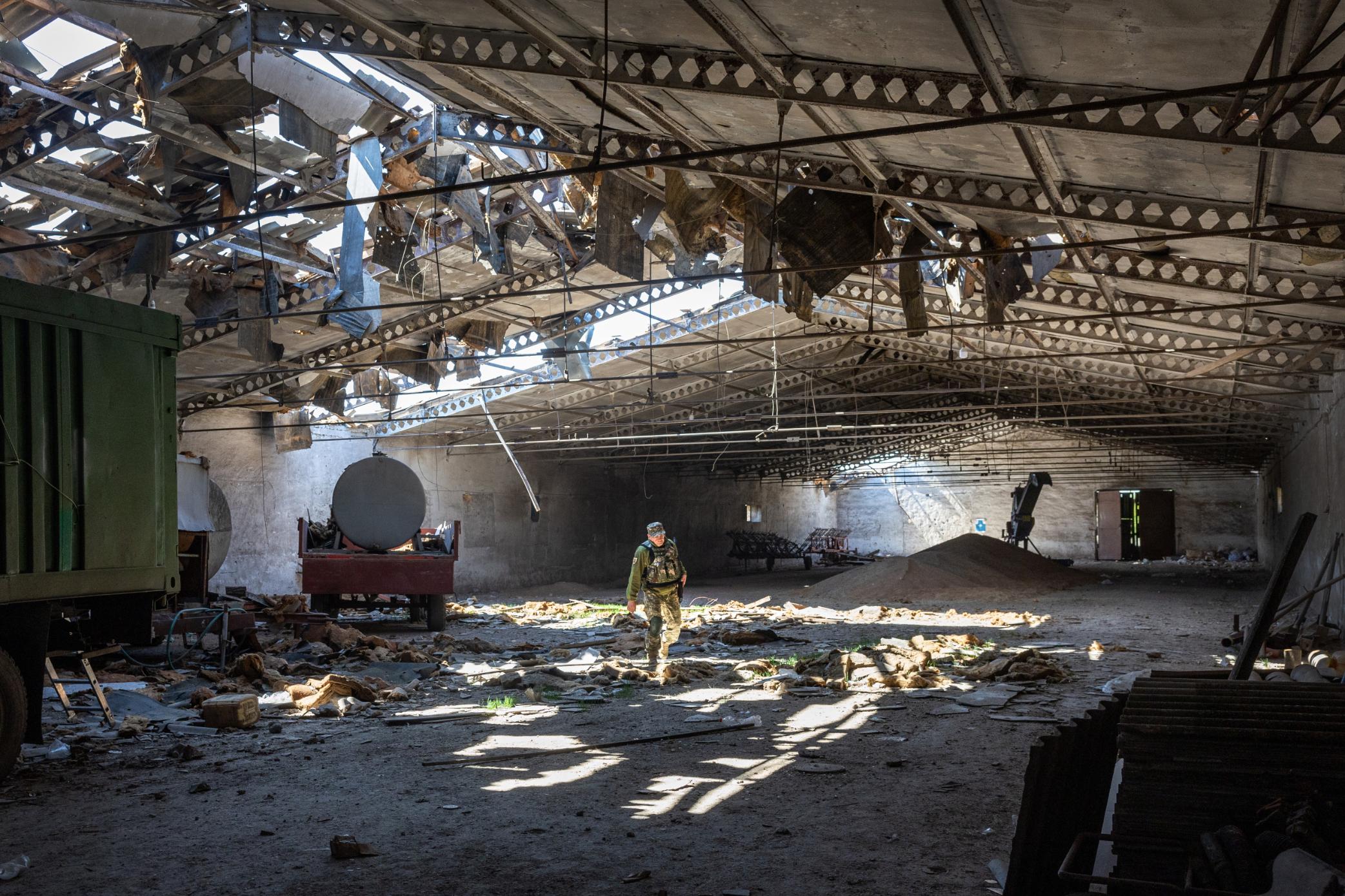 A Ukrainian army officer inspects a grain warehouse earlier shelled by Russian forces on May 6 in Novovorontsovka, Ukraine. 