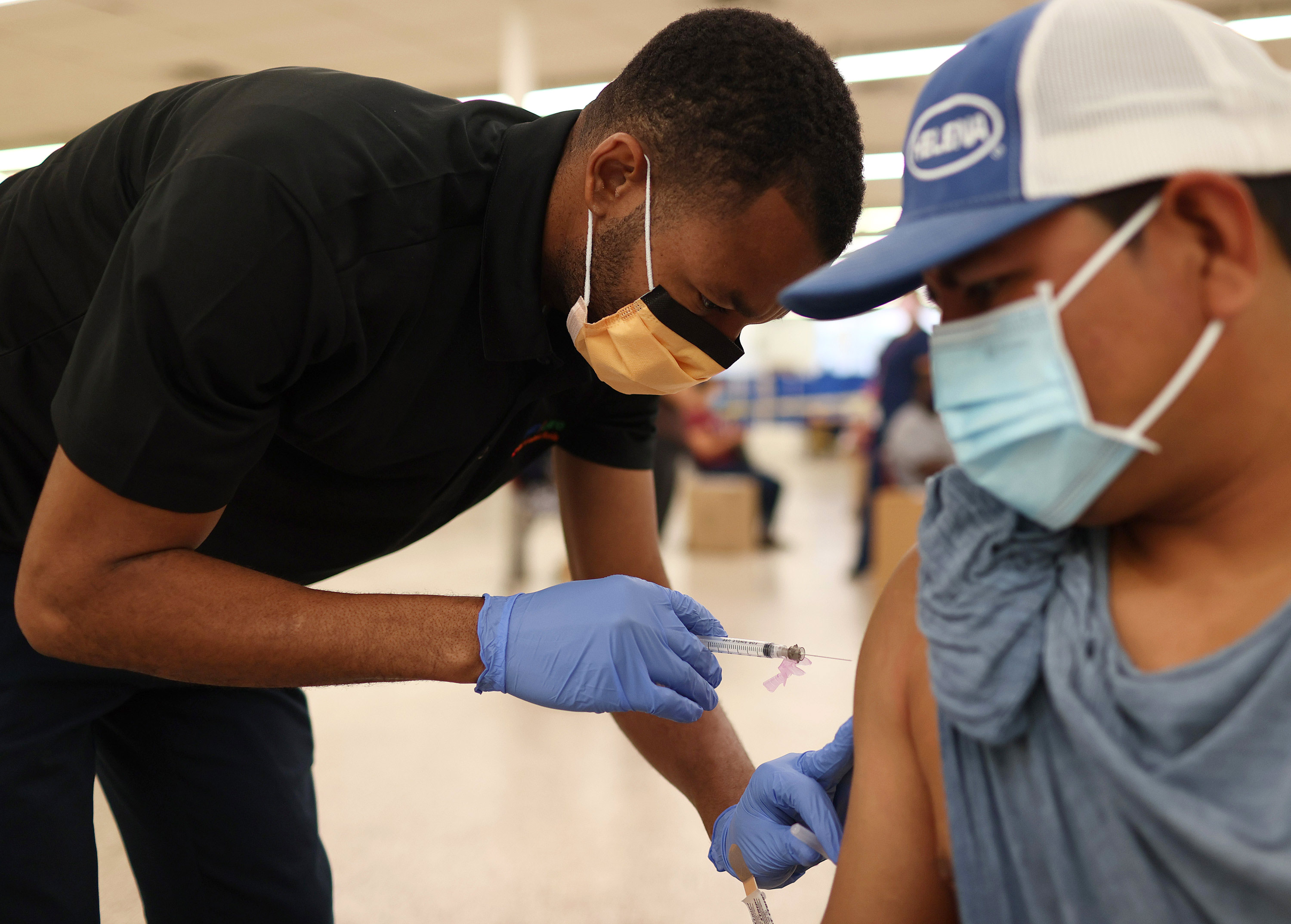 Odilest Guerrier, a medical assistant, administers a Moderna COVID-19 vaccine to Pasqual Cruz at a clinic on May 20 in Immokalee, Florida. 
