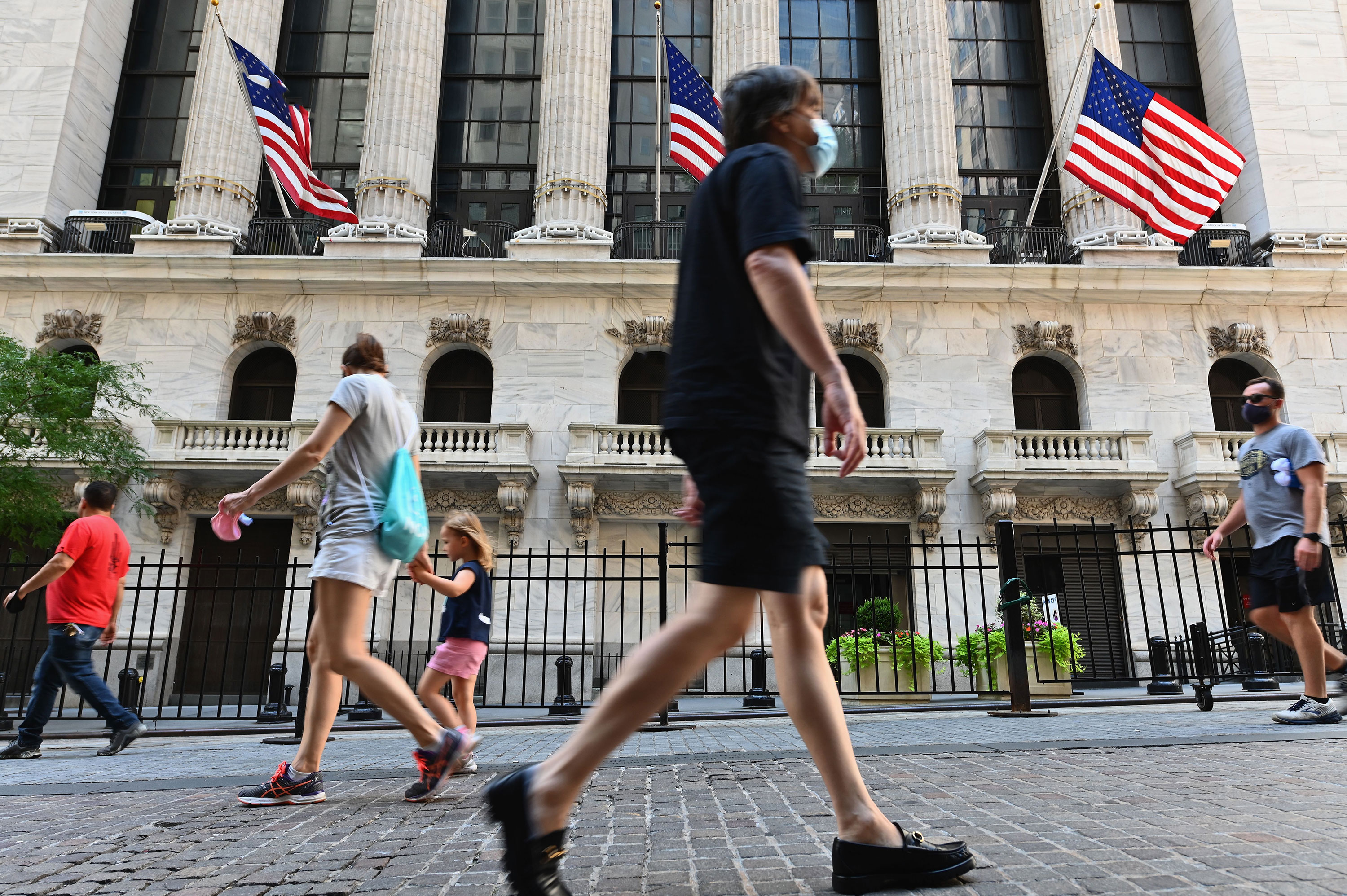 People walk past the New York Stock Exchange on August 3 in New York. 