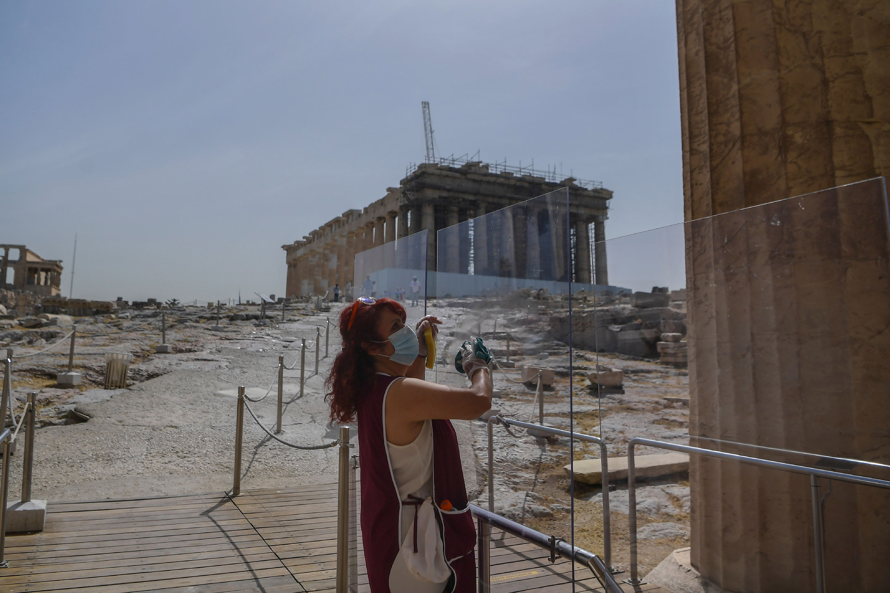 A worker wearing a protective mask cleans a divider at the entrance of the Acropolis in Athens, Greece, on May 18. 