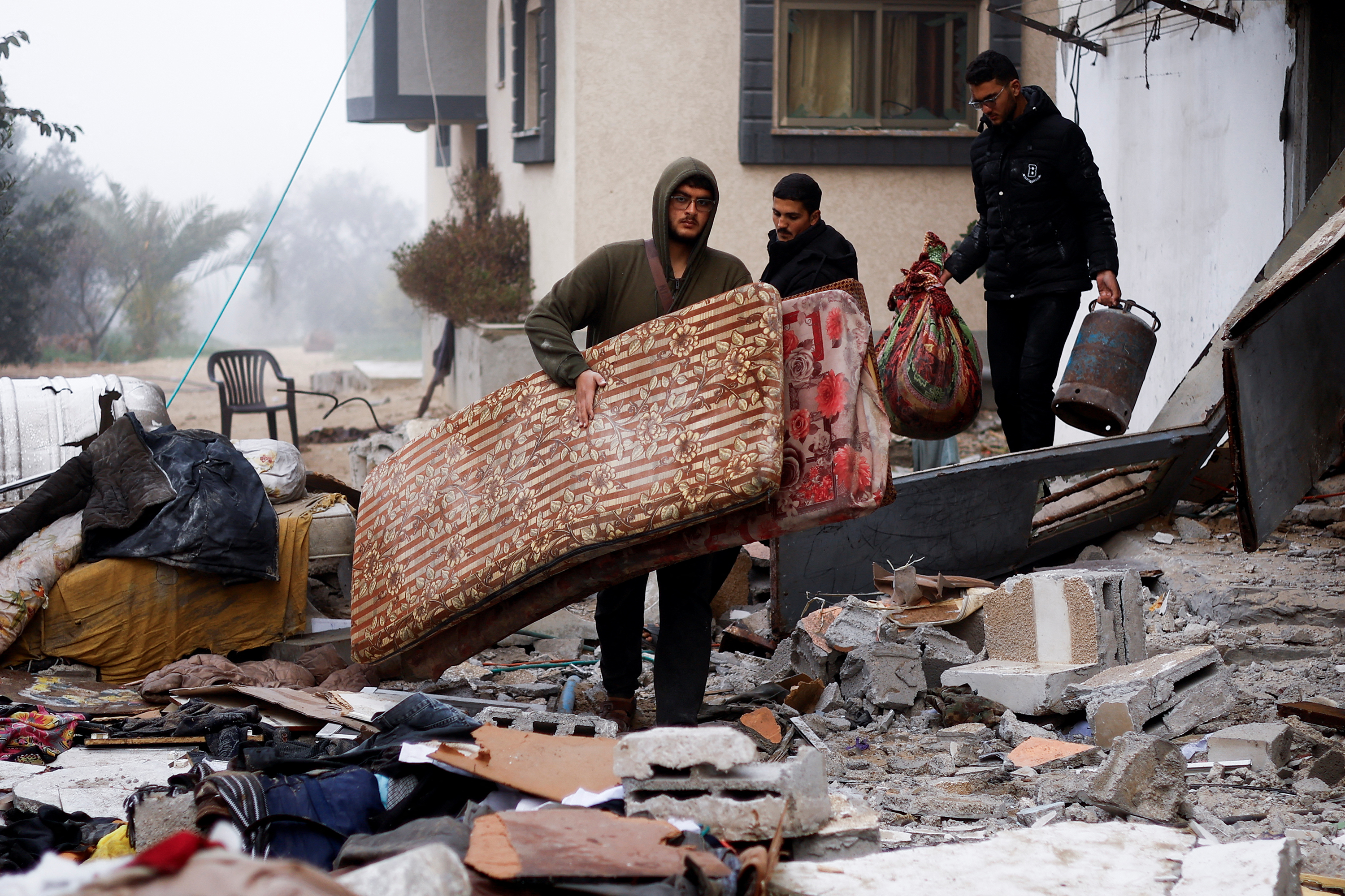 Palestinians carry belongings at the site of an Israeli strike on a house in Rafah, Gaza, on February 9.