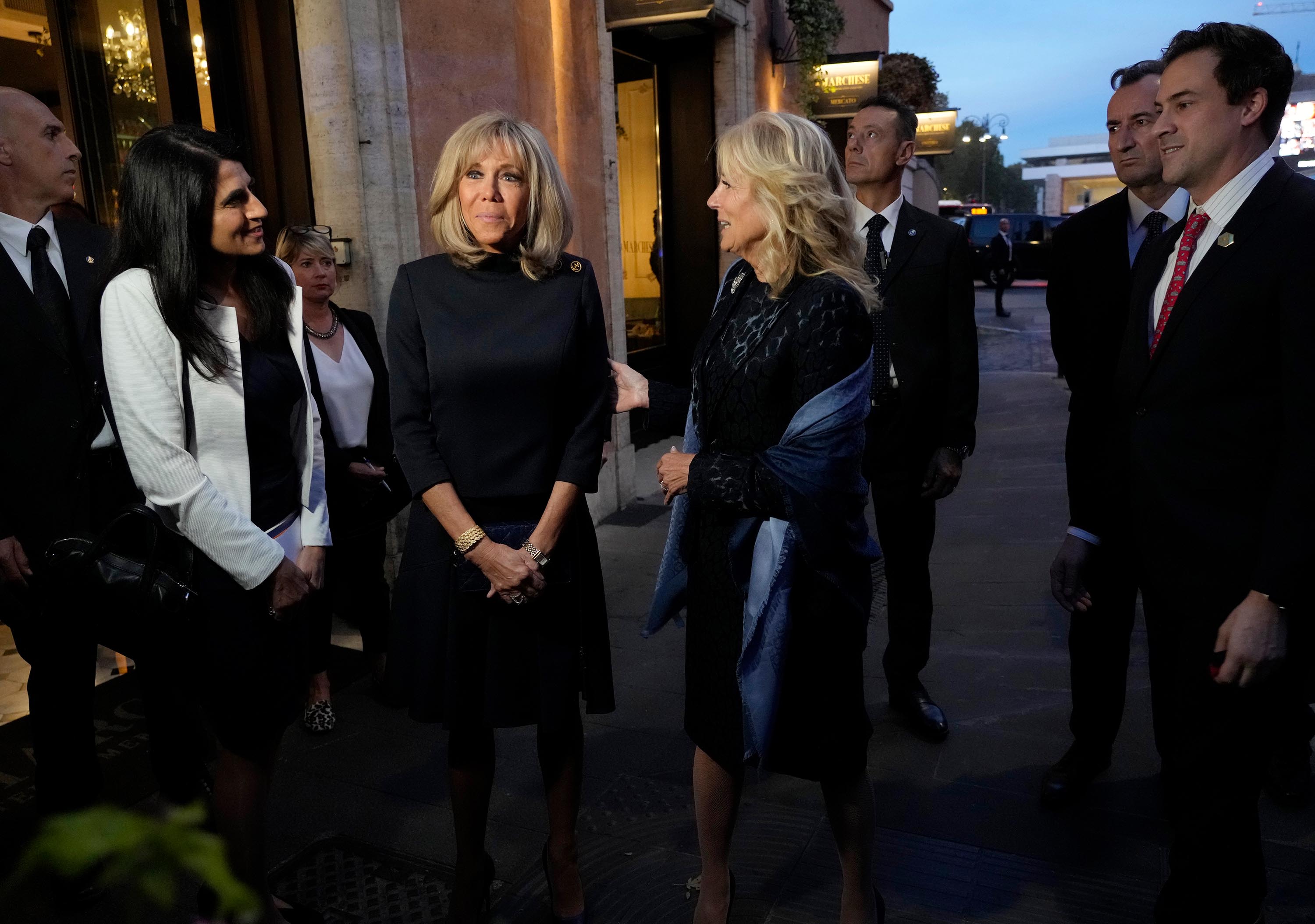 US first lady Jill Biden, center, and French first lady Brigitte Macron, center left, speak outside of a restaurant on the sidelines of an upcoming G20 summit in Rome, Friday, October 29.