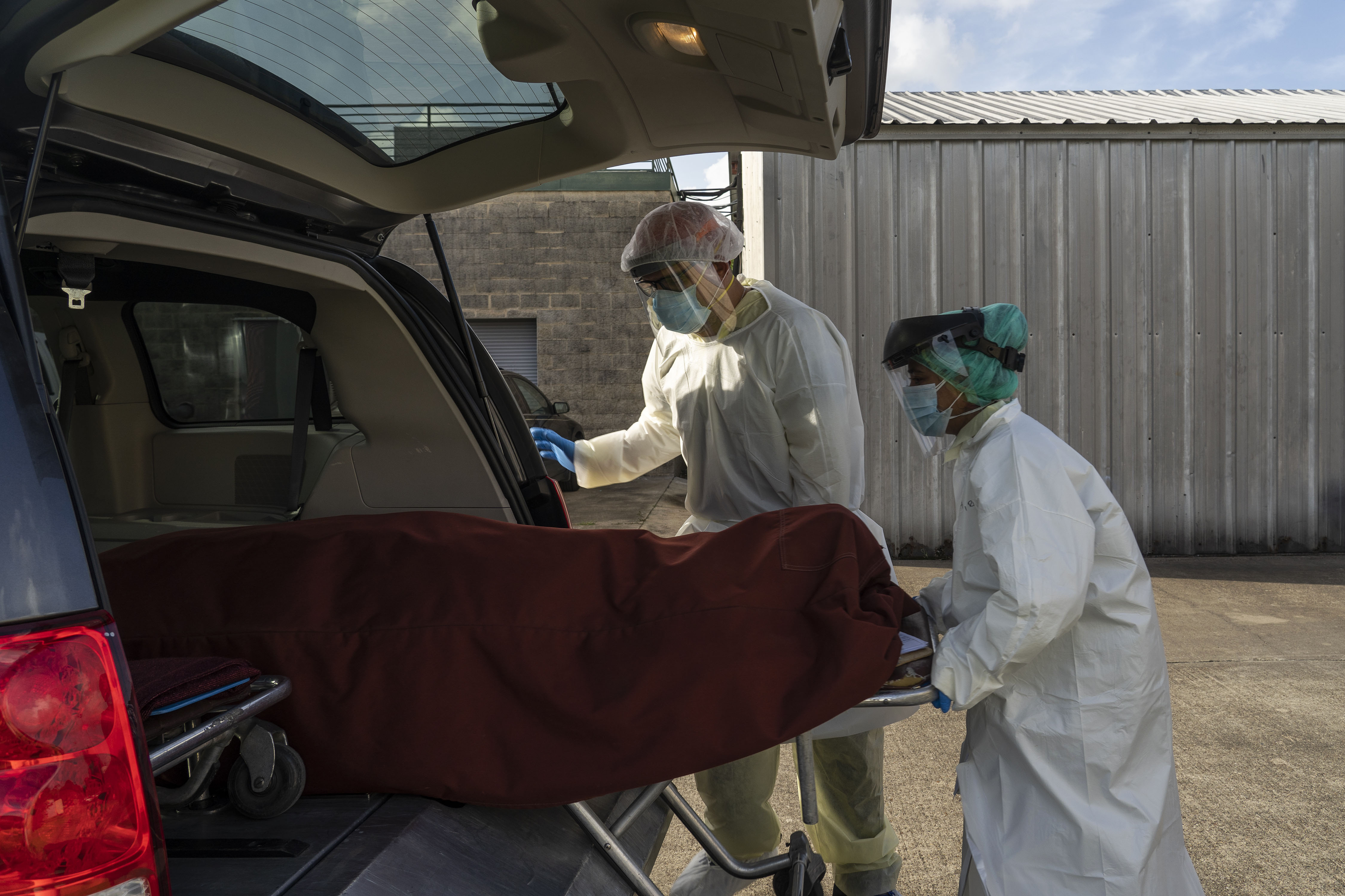 Medical staff in Houston push a stretcher with a deceased patient into a car outside the Covid-19 intensive care unit at United Memorial Medical Center on June 30.