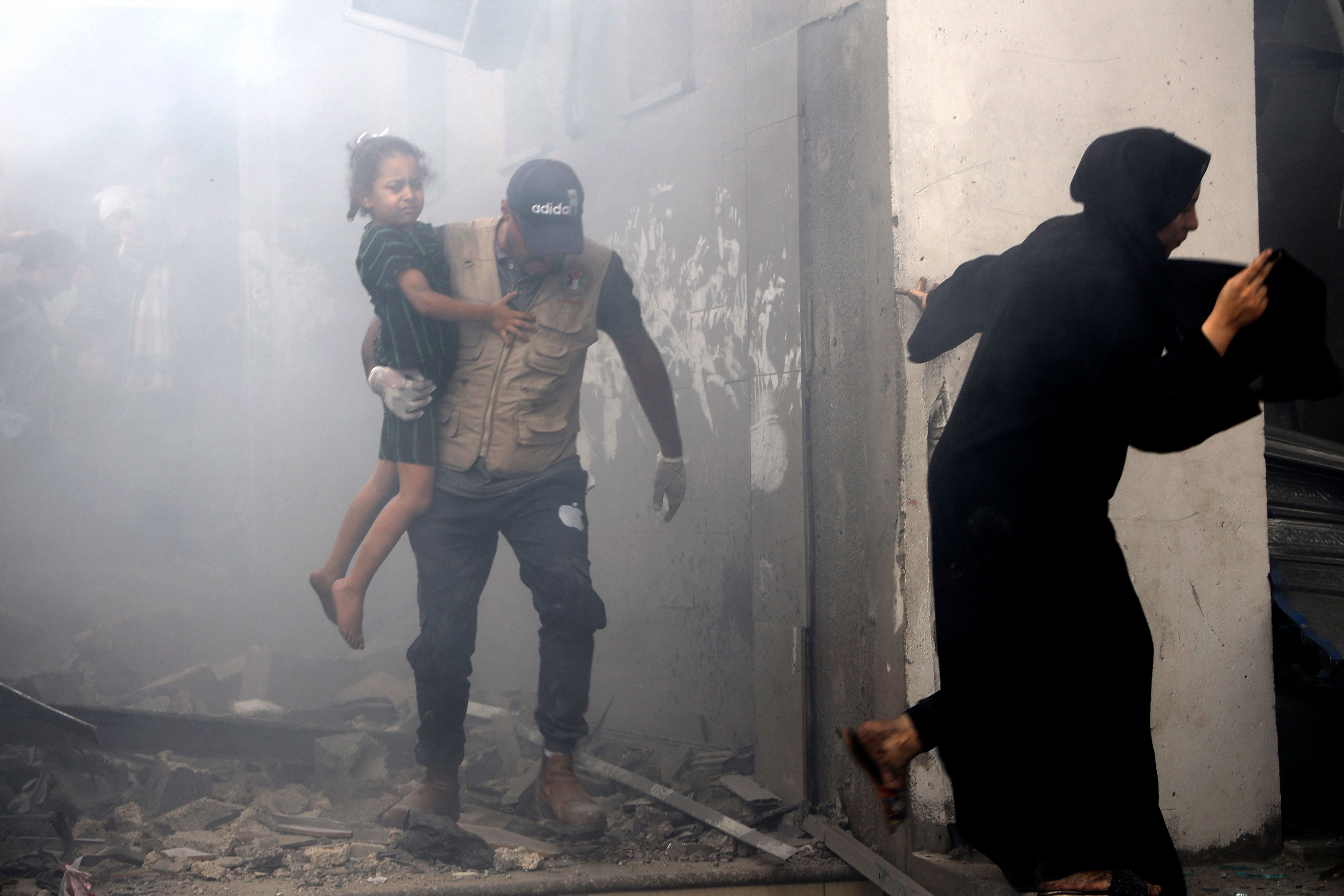 Members of a Palestinian family rush out of a bombed house during Israeli airstrikes on Gaza City on October 9, 2023.