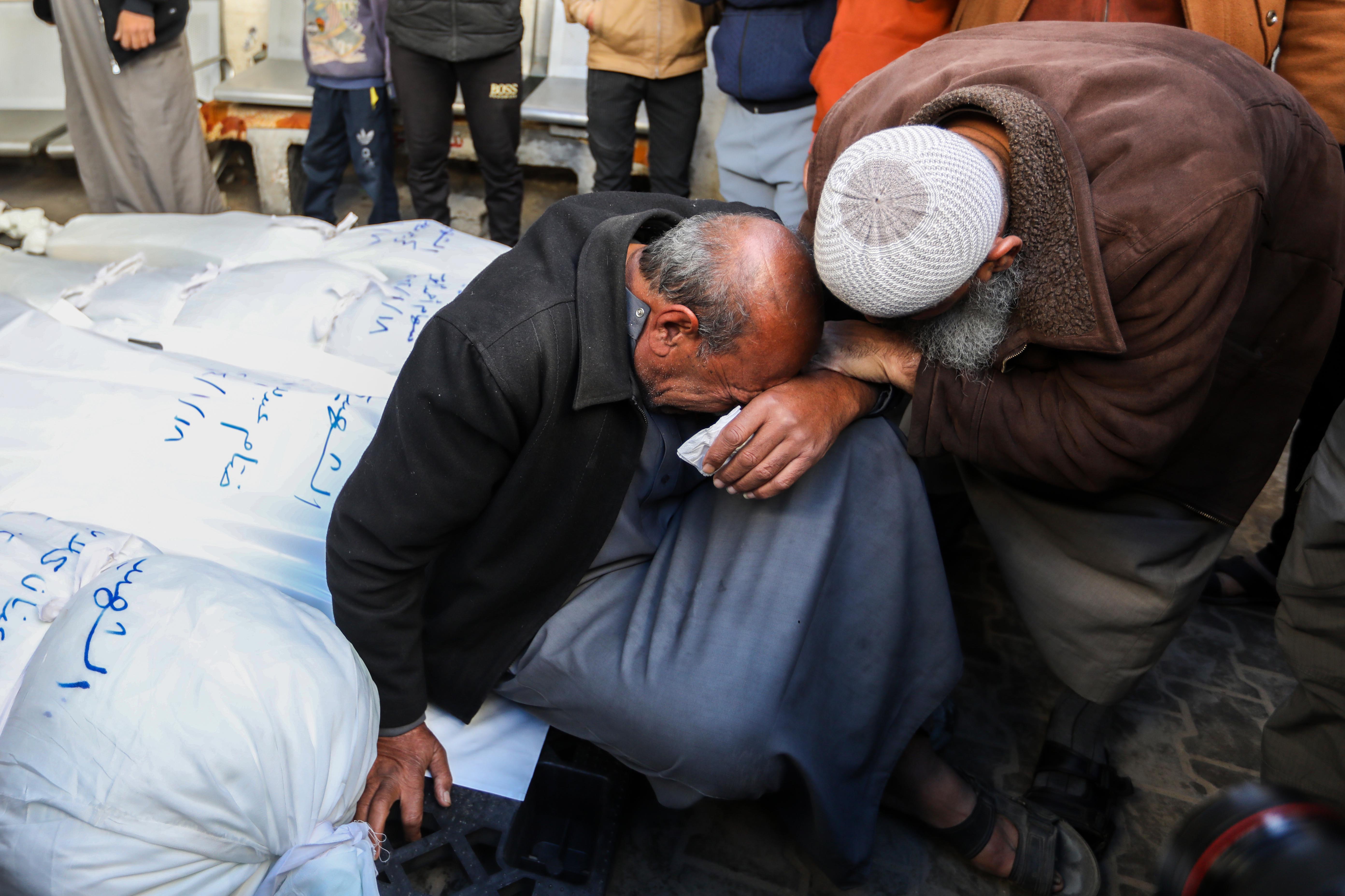 People mourn as they wait to collect the bodies of friends and relatives killed in an airstrike, on January 18, in Rafah, Gaza.