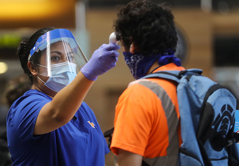 A traveler is checked with a handheld thermometer at Los Angeles International Airport on June 24.