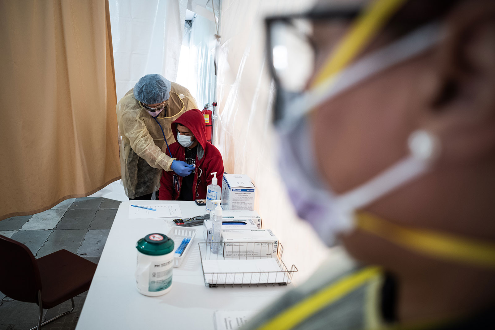 A doctor examines Juan Vasquez inside a testing tent at St. Barnabas hospital in New York City on March 20.